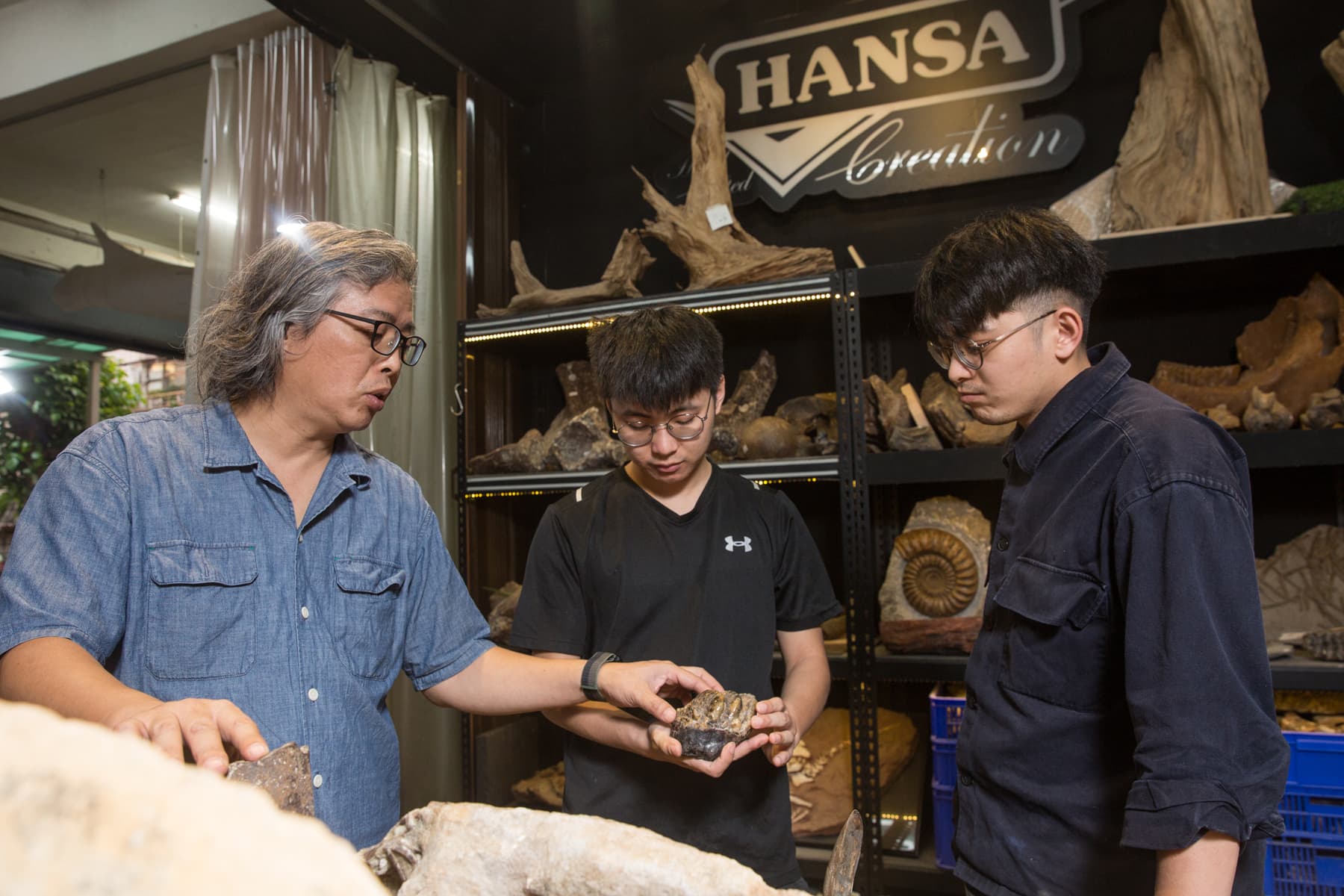 蕭語富（左）的二個兒子蕭琮諭（右）與蕭琮瑄(中)從小跟各種化石一起長大，現在都已經進公司幫忙。