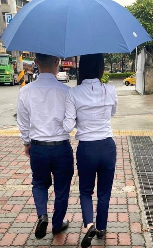 郭女與周男十分高調,甚至手挽著手同撐一把傘。(讀者提供)