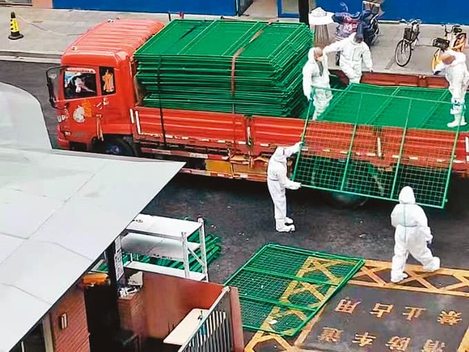 中國政府運來大量鐵網架封鎖小區。(翻攝自推特)