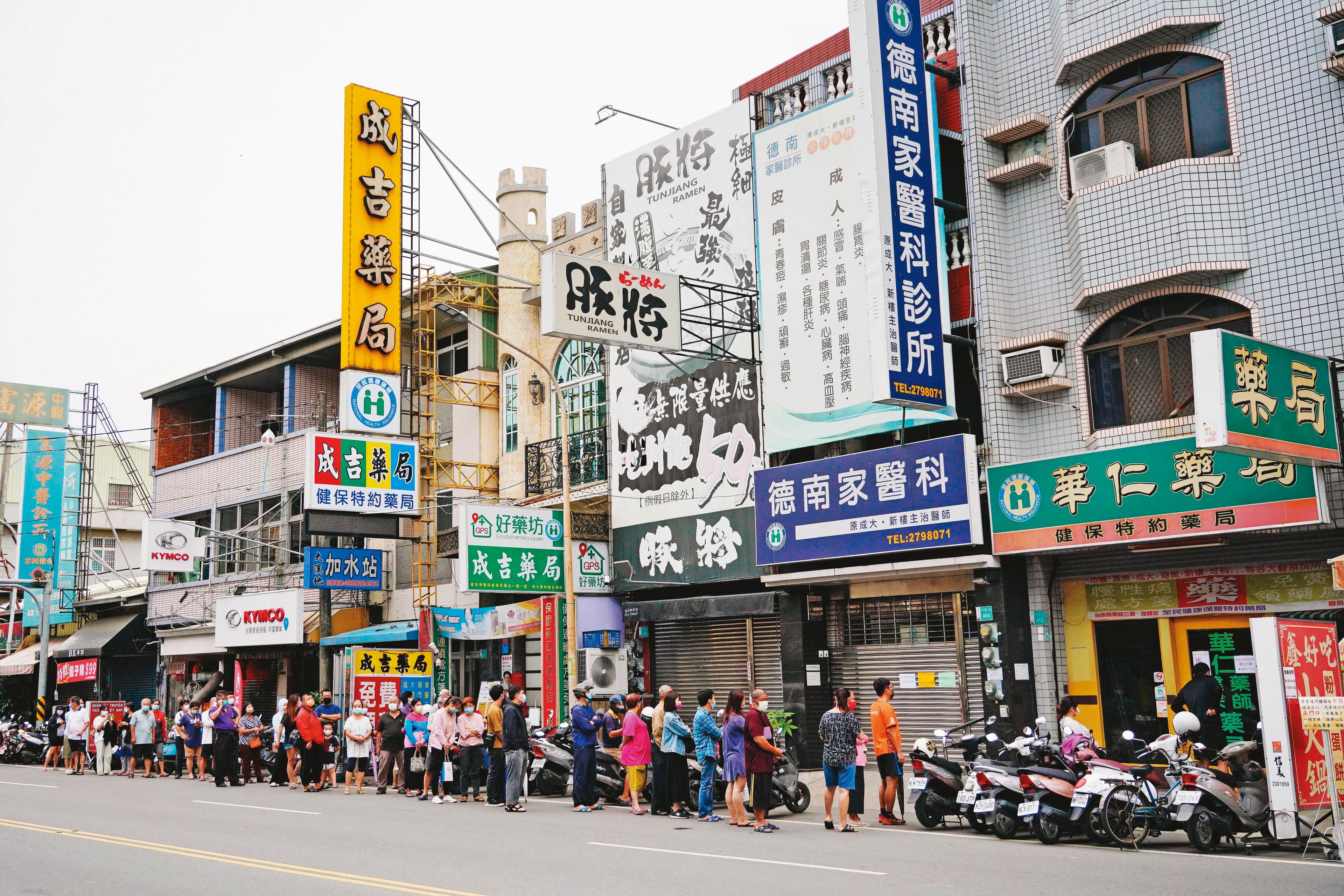 多項防疫措施鬆綁後,快篩劑成為重要防疫工具,搶買實名制快篩的民眾在藥局外大排長龍。