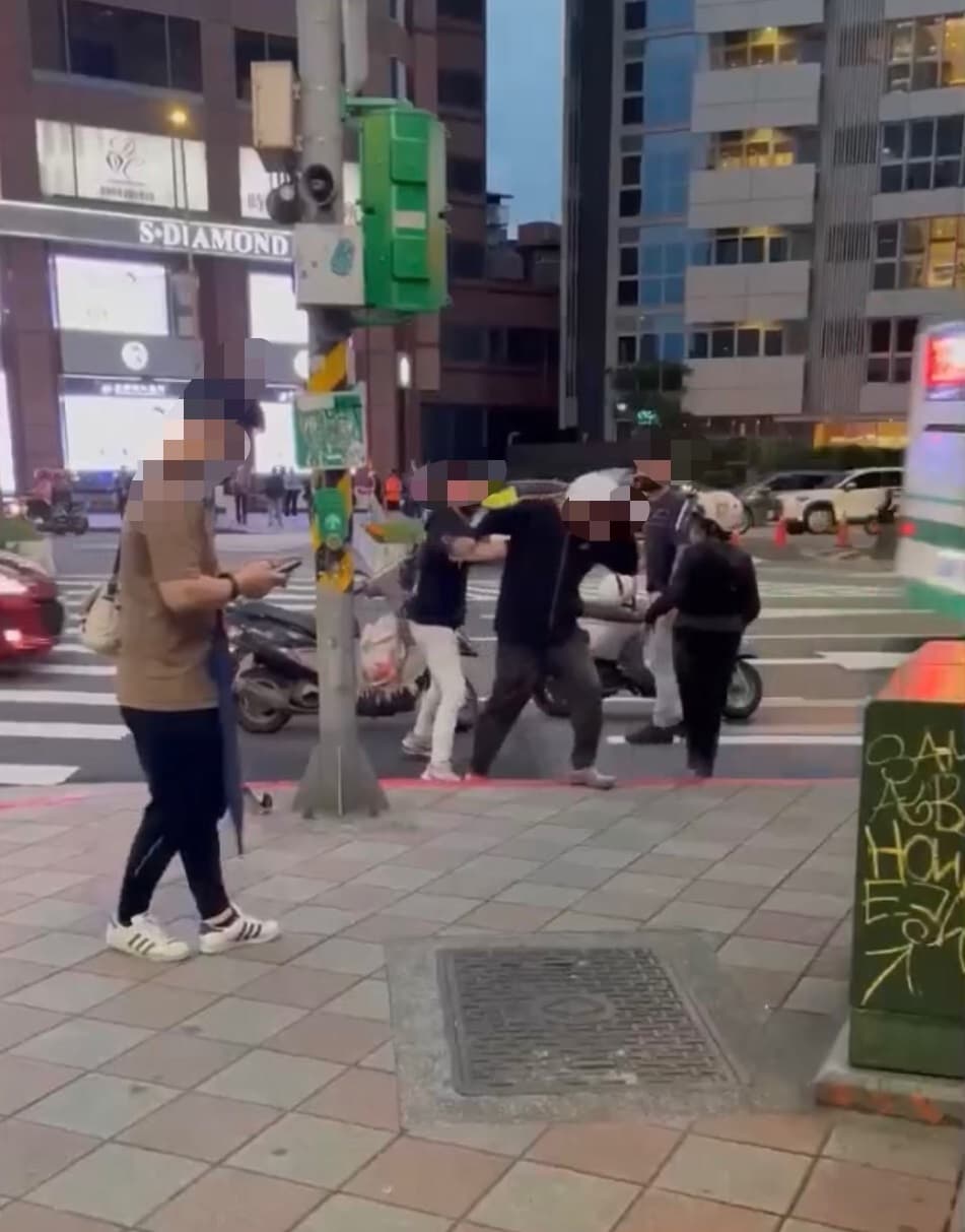 2名19歲少年當街持安全帽猛毆52歲的機車騎士。(翻攝自臉書爆料公社)