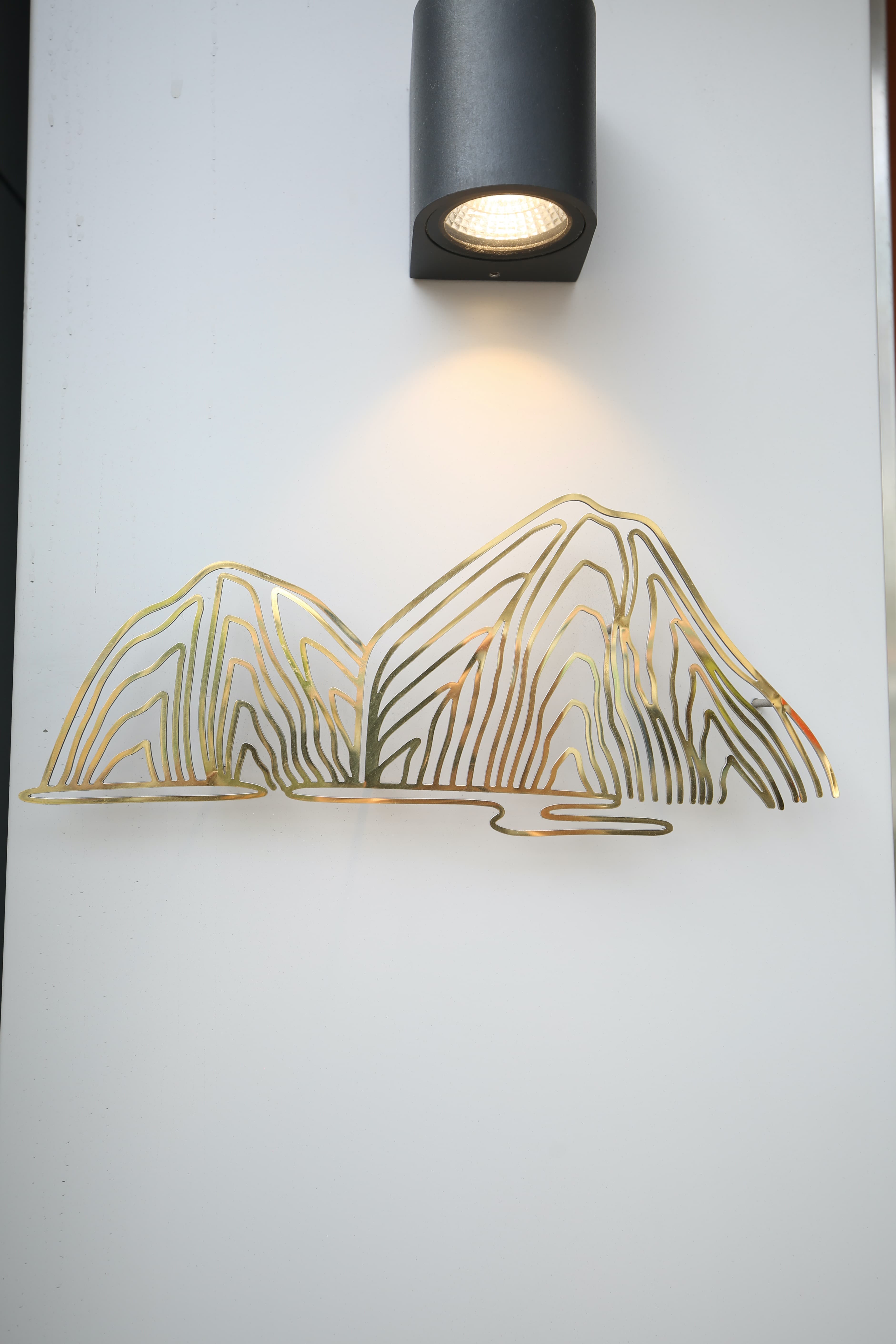 以鍍鈦打造的小籠湯包山谷logo,層疊聳立,帶有禪意。