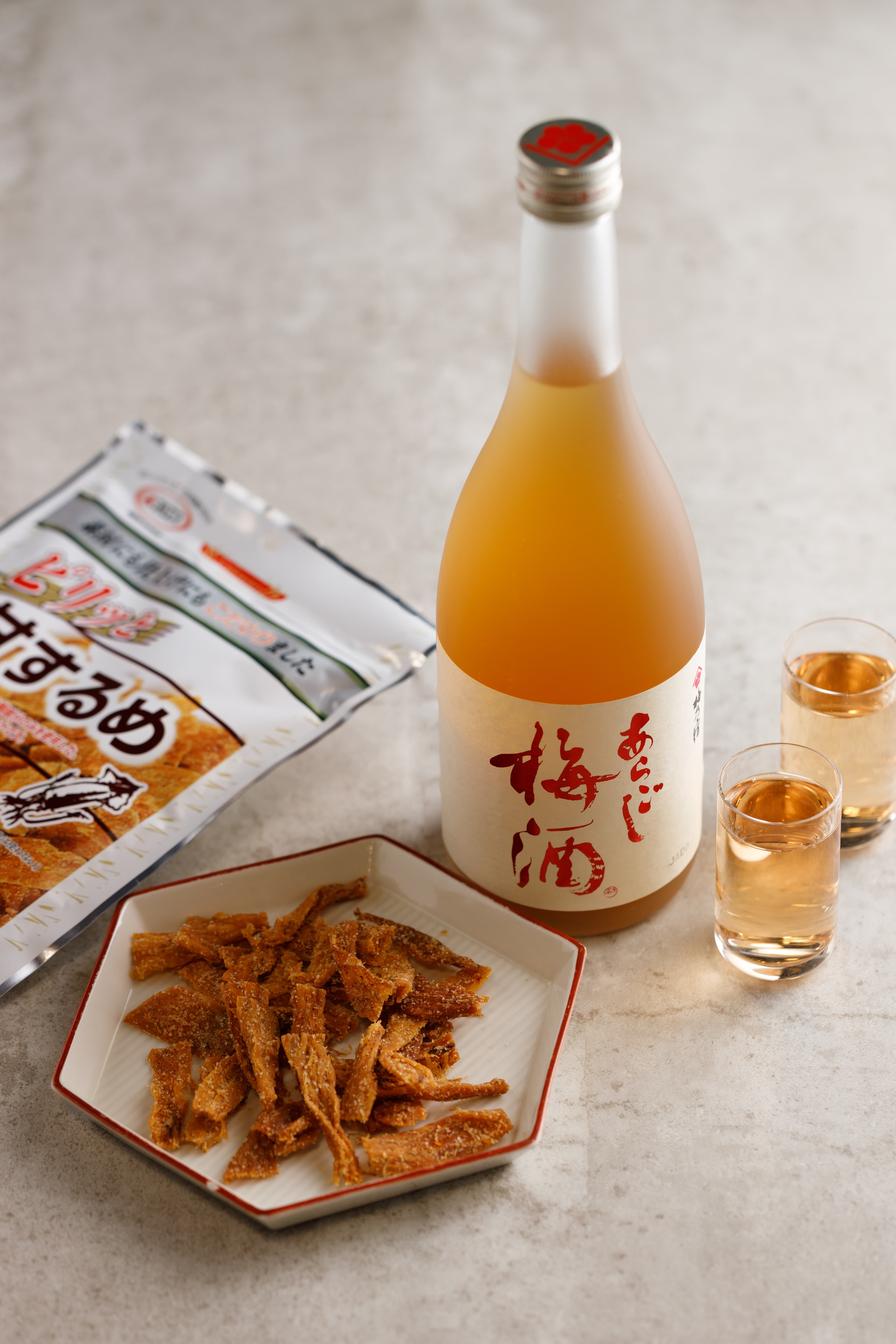 靜岡來的「花之舞 吟釀」(左,750元/瓶)喉韻清爽,帶有清甜果香與吟釀香,能撫慰被「辣味帆立貝」(右,490元/包)震撼的舌尖。