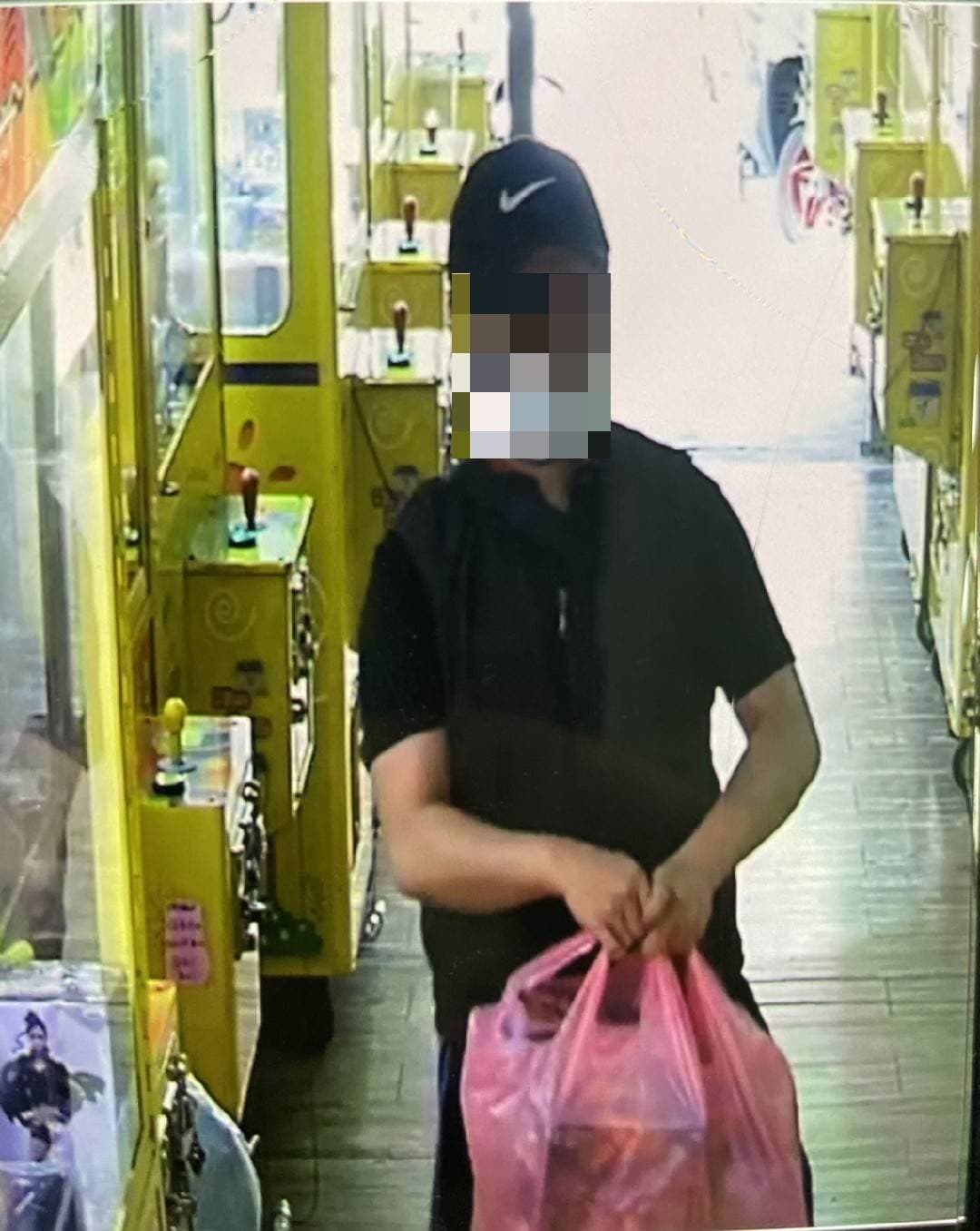 熊嫌將公仔贓物放進塑膠袋中。(警方提供)