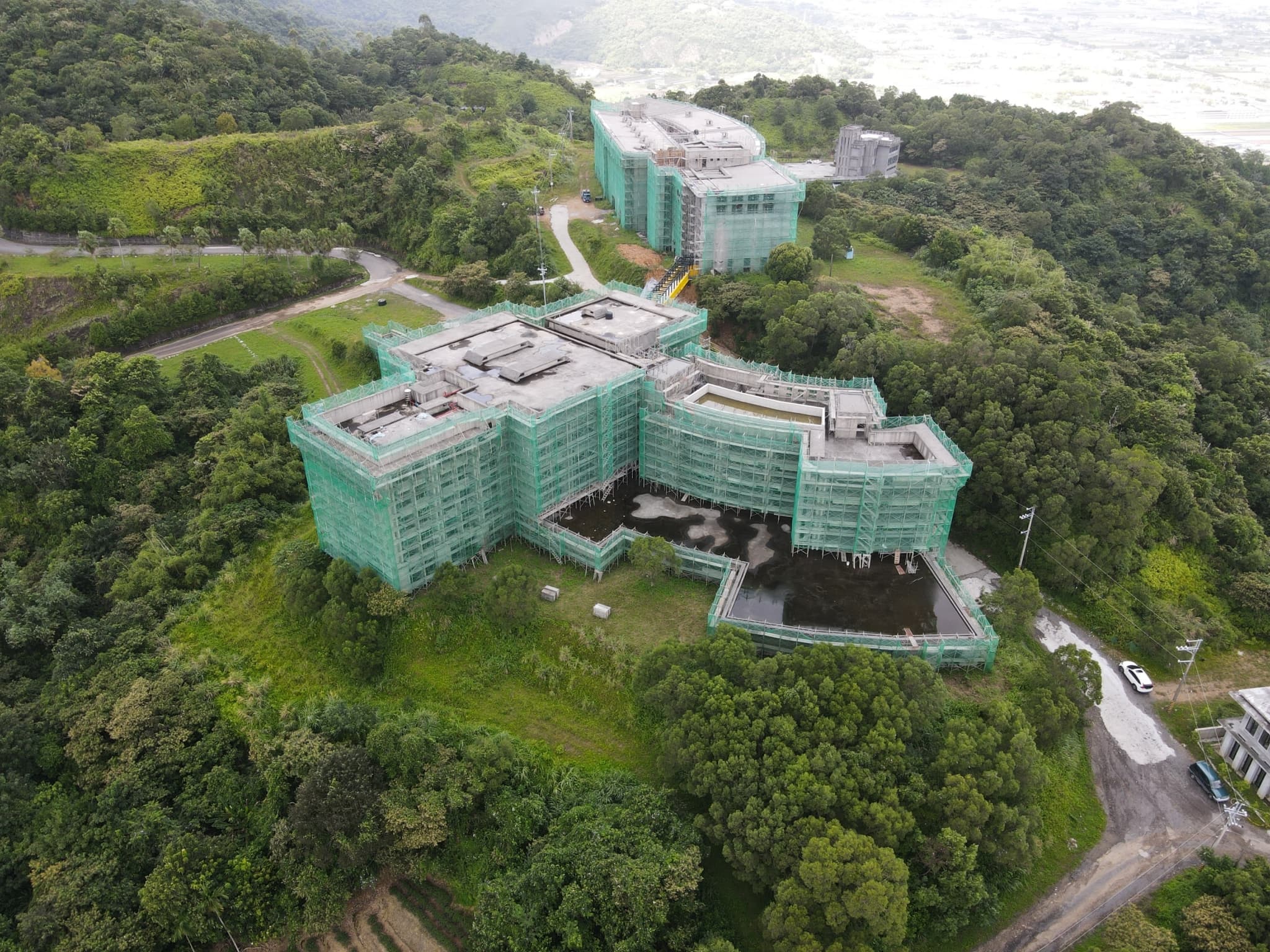 酒店主體結構座落在三星鄉草湖天公廟「玉尊宮」後方山坡地。（張世鈺提供）