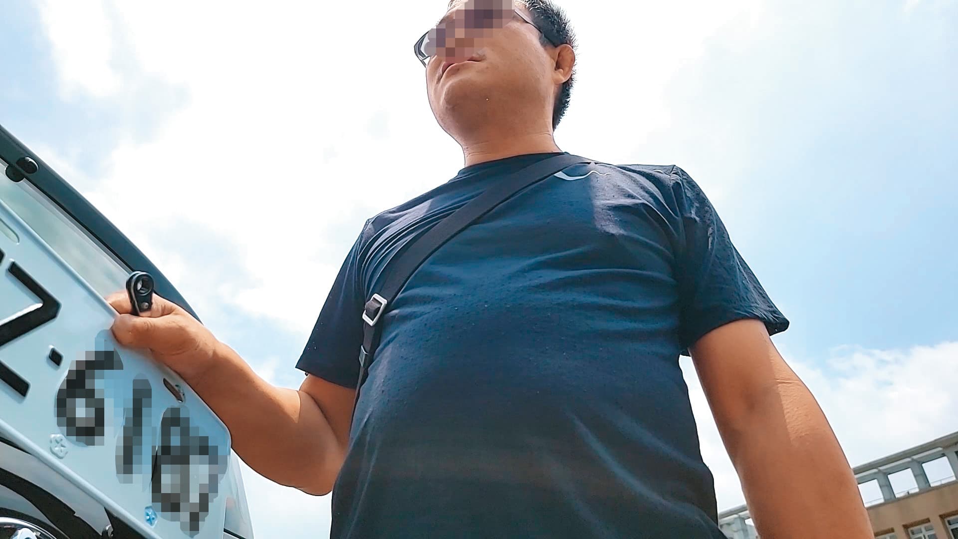 代辦業者拿著車牌怒瞪當事人,叫她不要多問。(讀者提供)