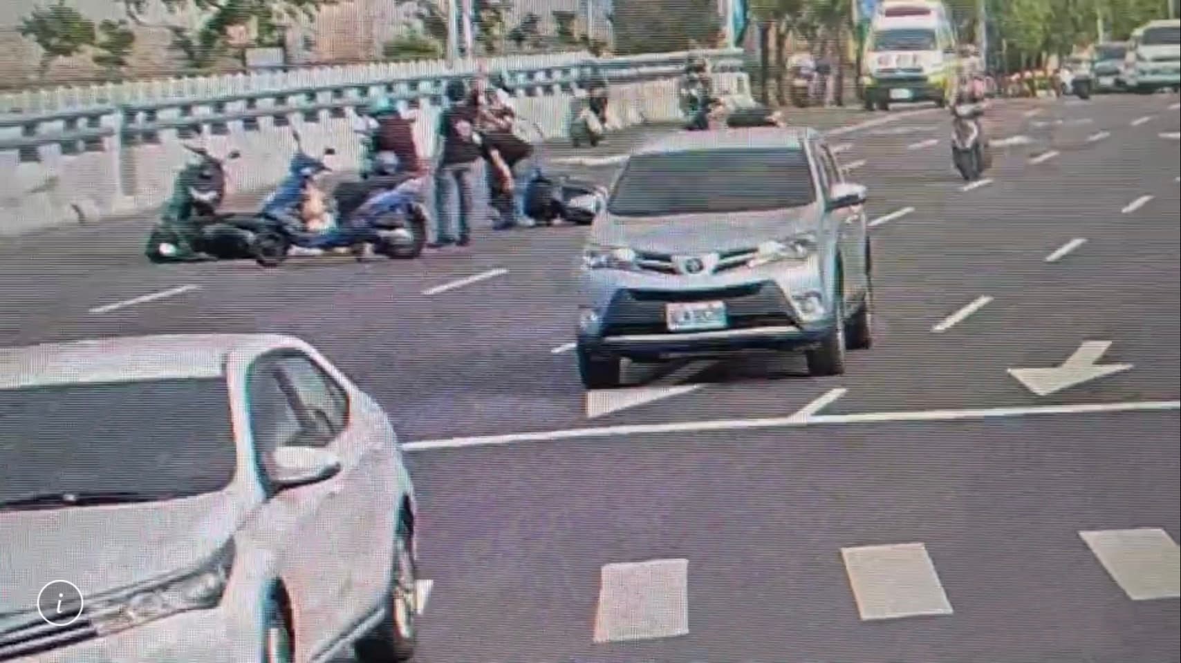 車禍發生後,多名熱心民眾將機車擋在事故現場前避免追撞。(翻攝畫面)