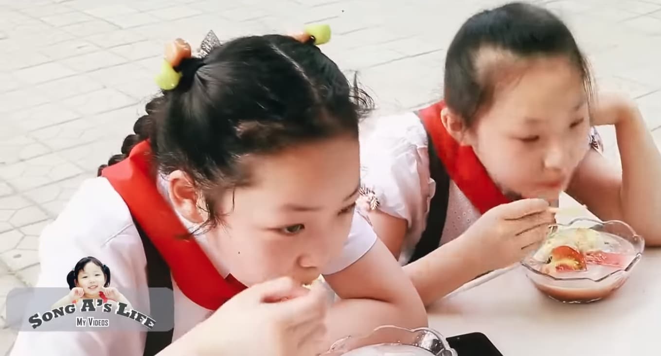 松雅（左）和朋友一同開箱北韓冰品，吃得津津有味。（翻攝自 Sary Voline [송아 SongA Vlog] YouTube）