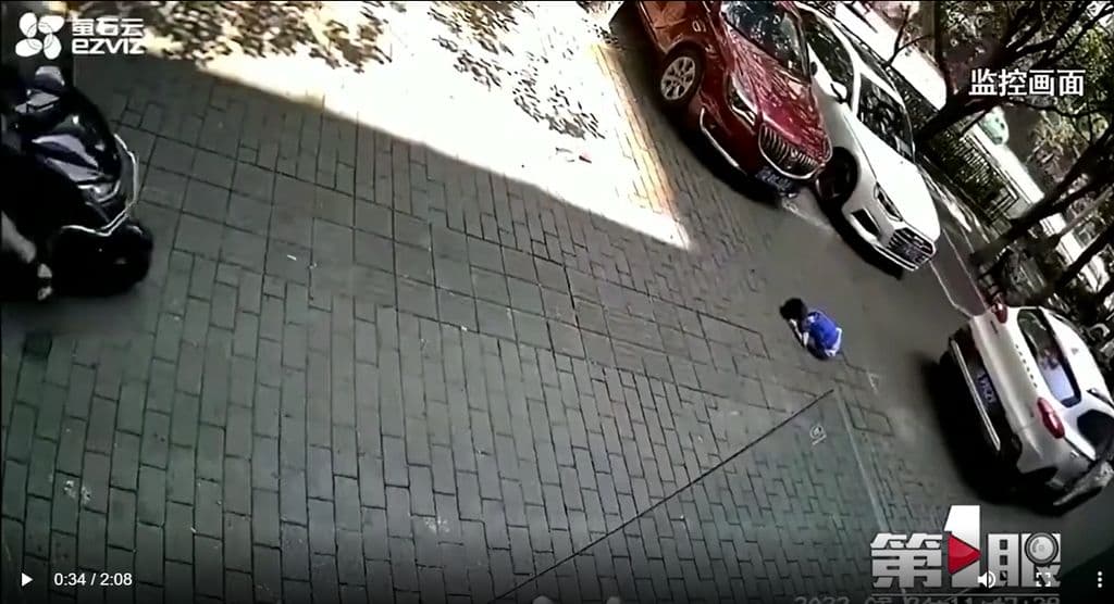 男童被車子的前輪和後輪輾過,一動也不動。(翻攝微博)