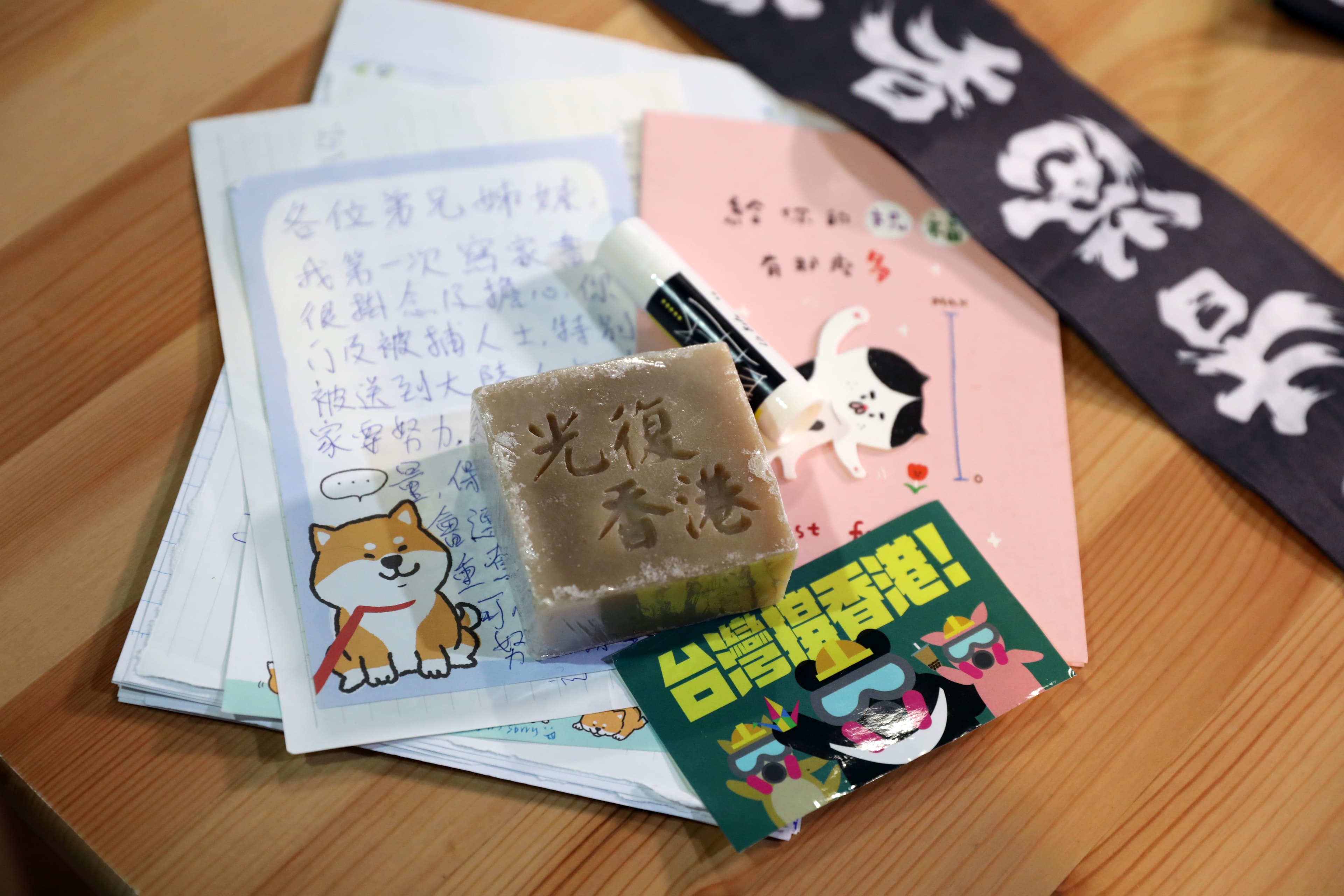 2年前Absent受訪時，隨身攜帶她珍惜保存的物件：港人寄到台灣的卡片、信件、貼紙。圖中刻有「光復香港」的肥皂，是流亡港人以手工自製的商品。