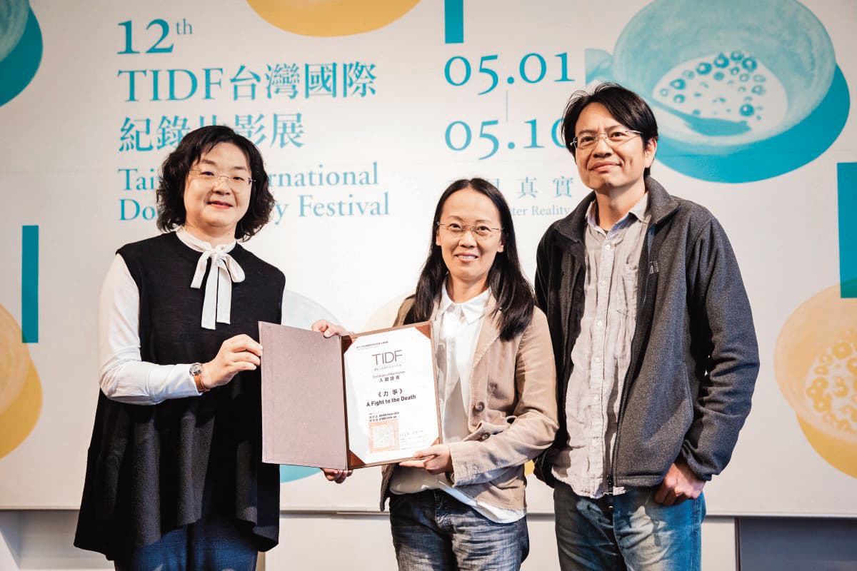 謝欣志(右起)與陳芝安2020年以《力爭》入圍台灣國際紀錄片影展台灣競賽單元,由文化部影視局局長徐宜君(左)頒發證書。(TIDF提供)