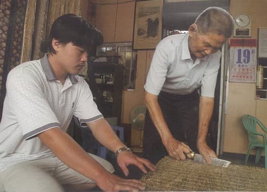 李宗勳(左)2008年回到泉興,向爺爺李金水(右)學習製作榻榻米手藝。(泉興榻榻米提供)