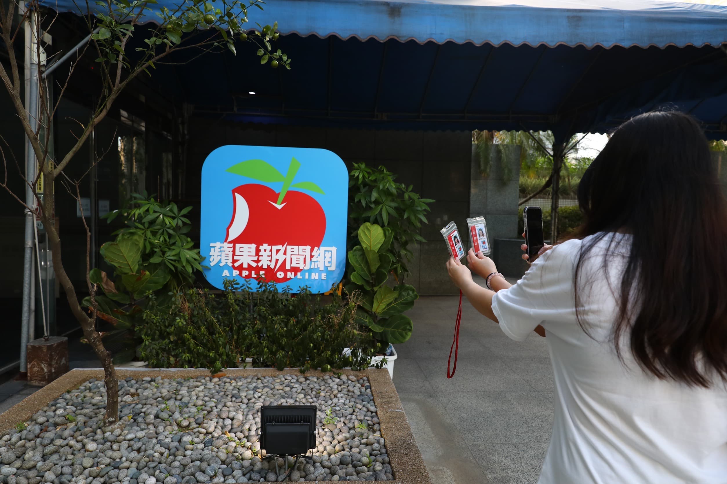 《蘋果新聞網》員工拿識別證和logo合影留念。