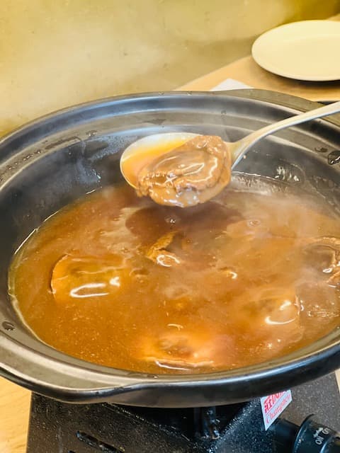 鮑魚浸在濃郁的鮑汁內慢火溫煮,上桌前才撈起。