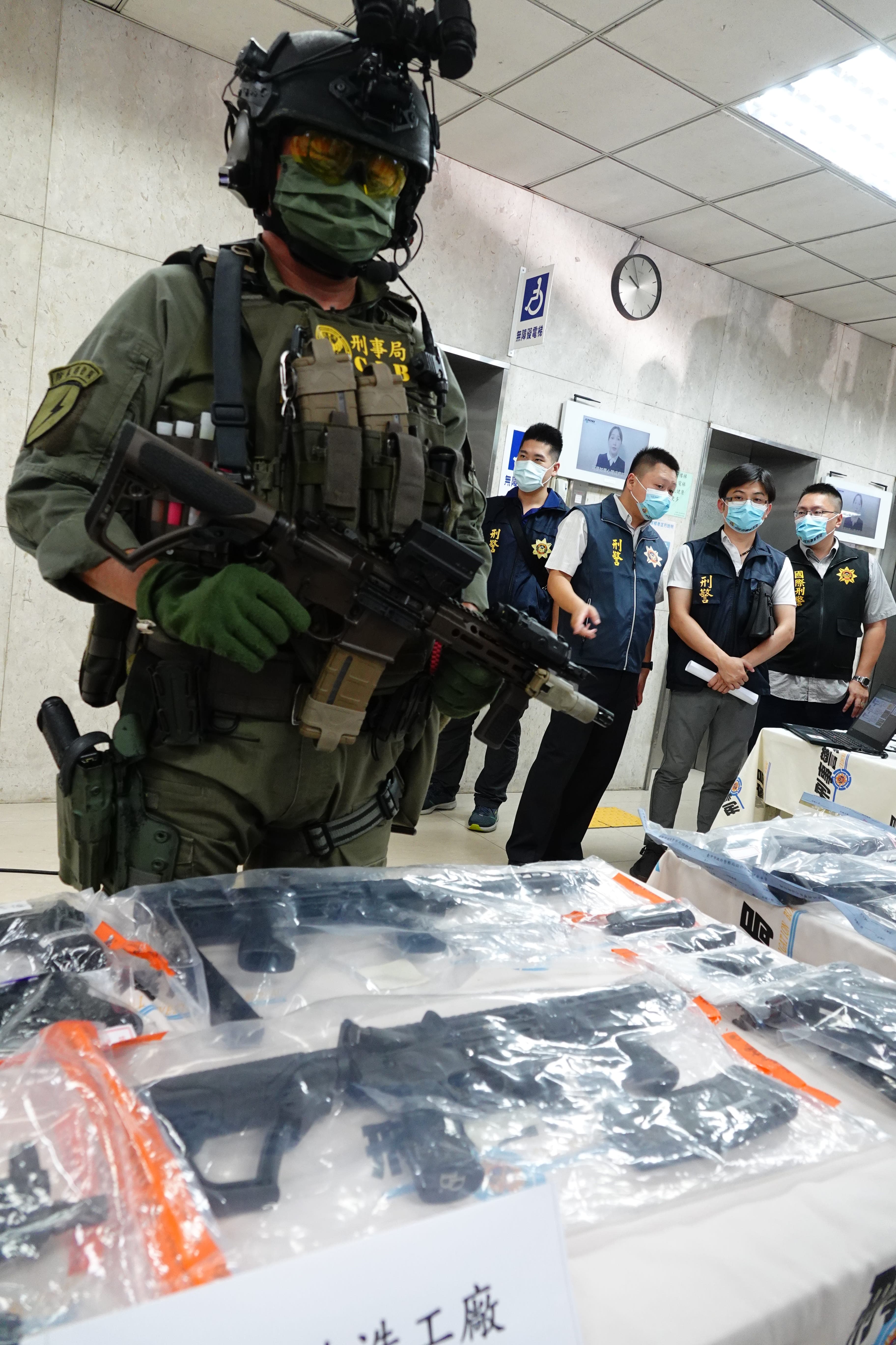 刑事局查獲罕見改造MK18短版卡賓槍(前方桌上),後方除暴特勤隊員手持制式MK18。