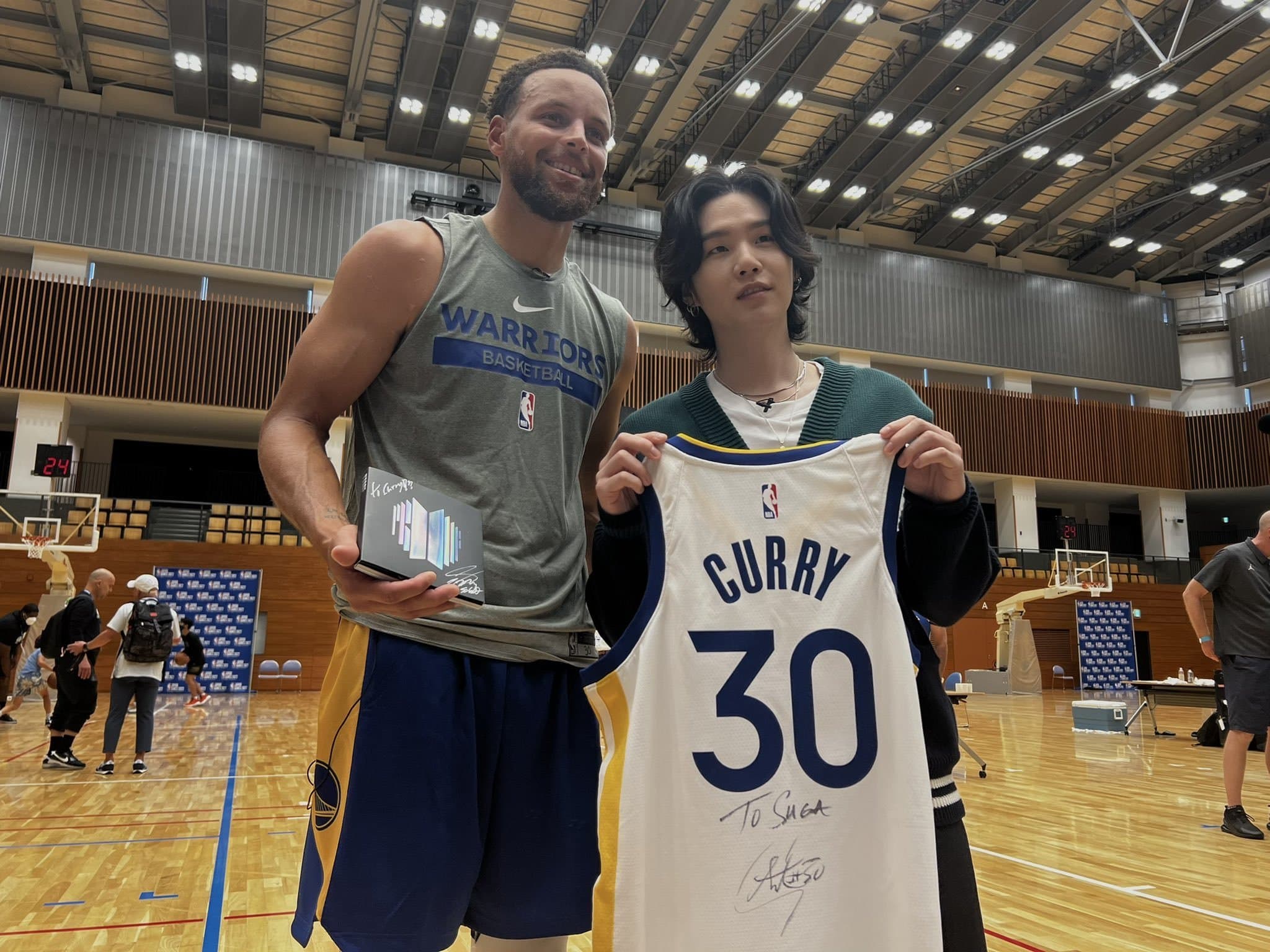SUGA在日本與NBA勇士隊球星科瑞相見歡。(翻攝NBA推特)