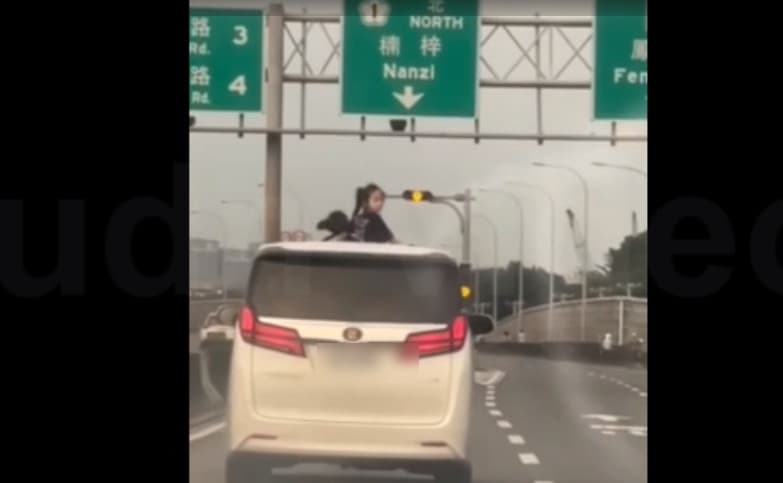 國道上有2名女童上半身探出車頂天窗兜風,危險行徑恐讓開車的家長吃上罰單。(翻攝臉書社團《爆料公社公開版》)