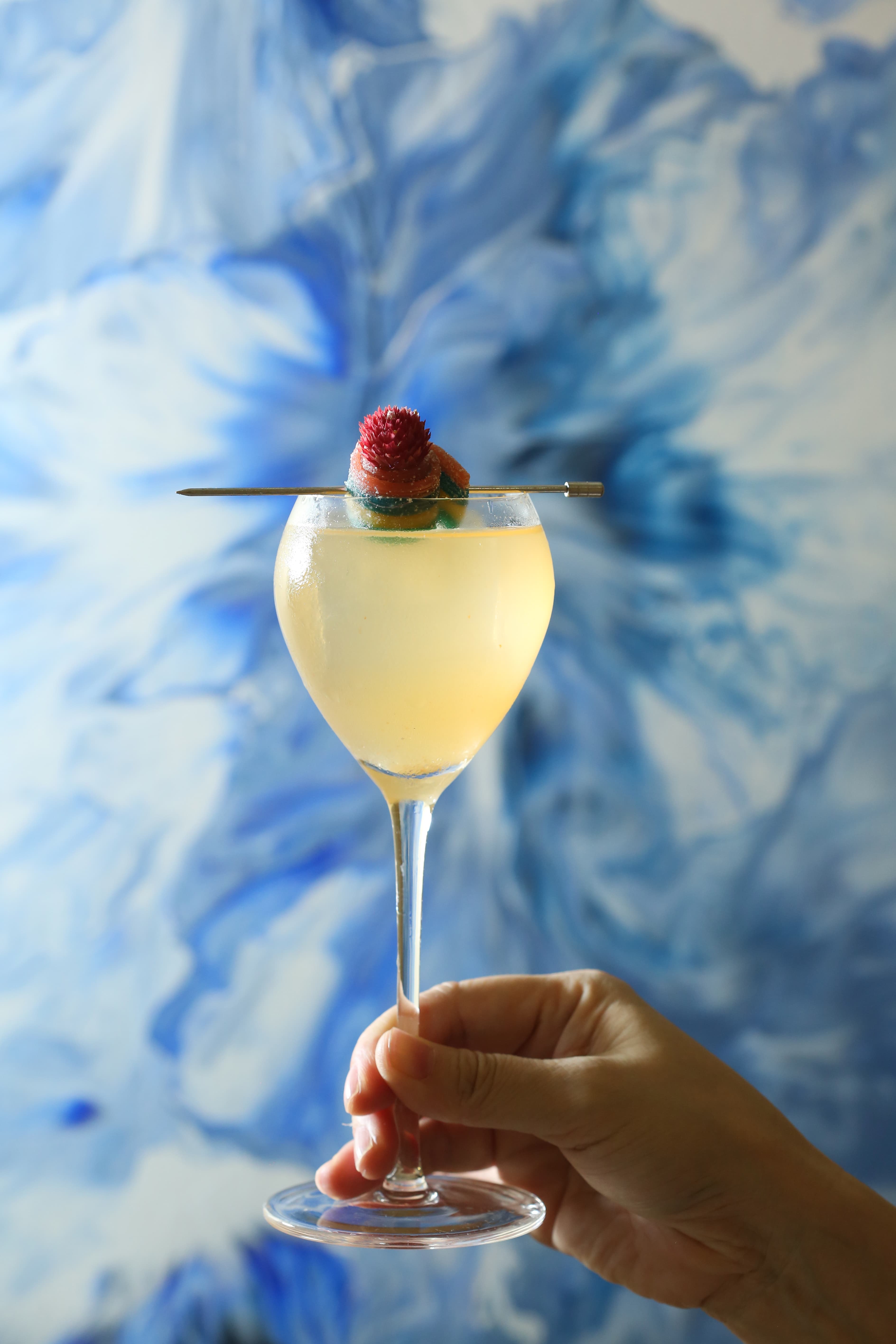 相對於中式青花的《諾瓦利斯藍花》，以香草伏特加調製的「Pornstan Martini」，帶點葡萄柚的奶香風格，棒棒糖則象徵流動的情欲。（400元／杯）