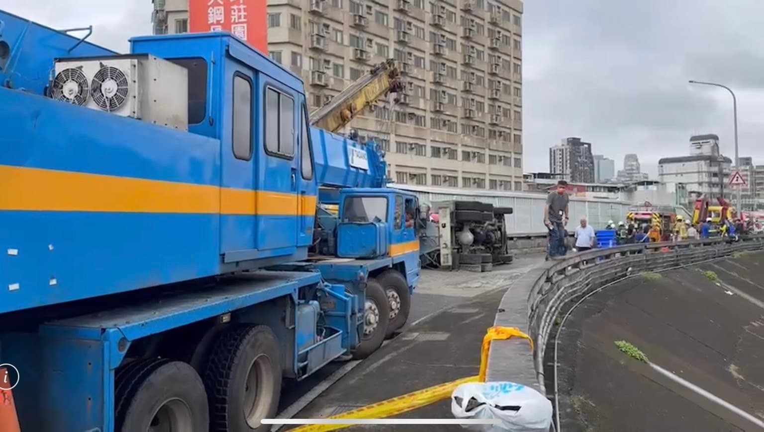 預拌車翻覆意外造成路面滿是水泥,吊車隨後到場將車輛吊離。(翻攝畫面)