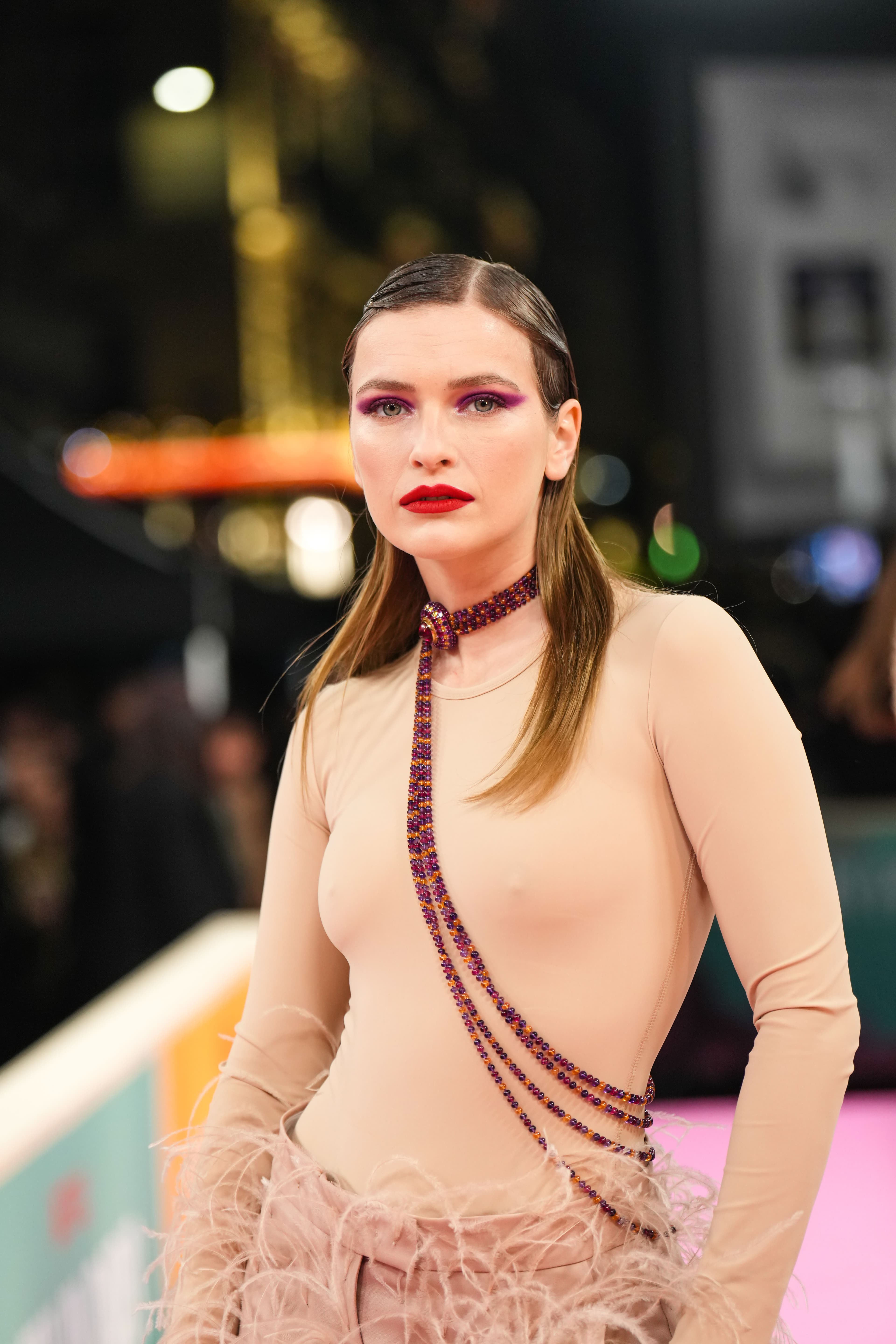 卡蜜兒塞拉萊穿著肉色貼身上衣，下半身搭配羽毛長褲。（Netflix提供）