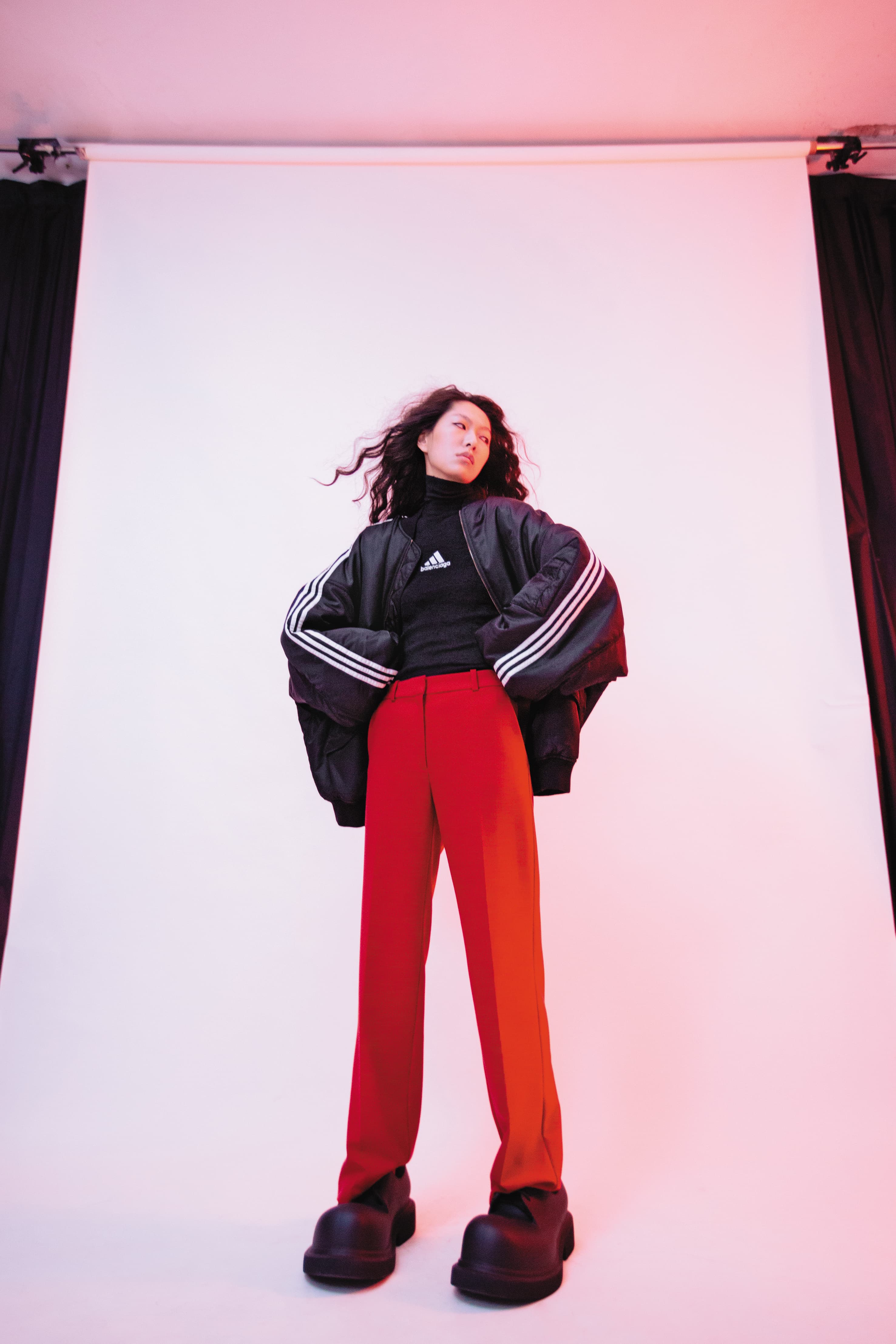 黑色oversize運動外套 價格店洽 by BALENCIAGA／黑色高領聯名上衣 價格店洽 by BALENCIAGA／紅色西裝長褲 NT$9,990 by MAJE／黑色大頭鞋 價格店洽 by BALENCIAGA
