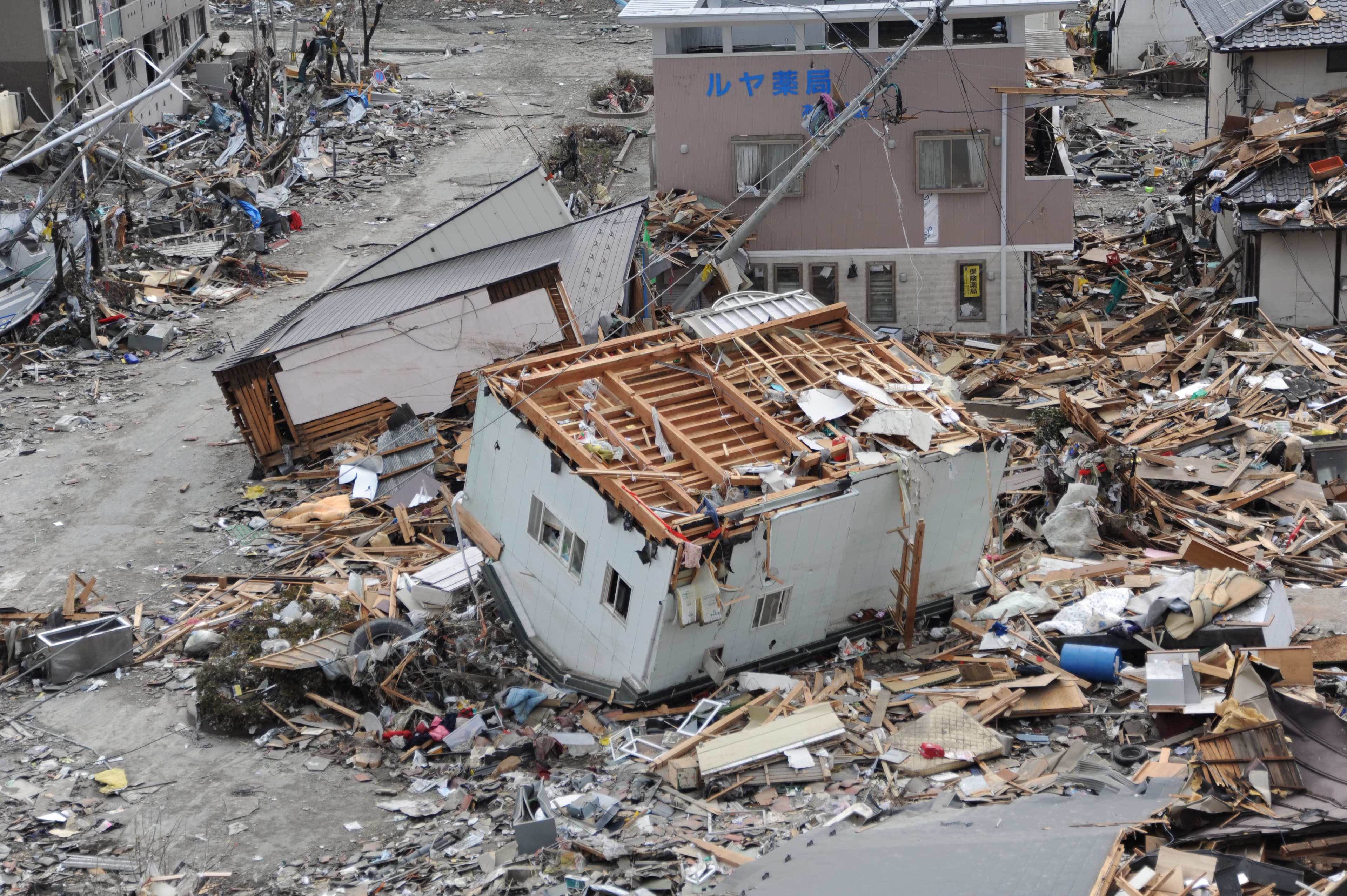 日本311大地震,在岩手縣大船渡市被巨大海嘯破壞四散的房屋。(翻攝維基百科)