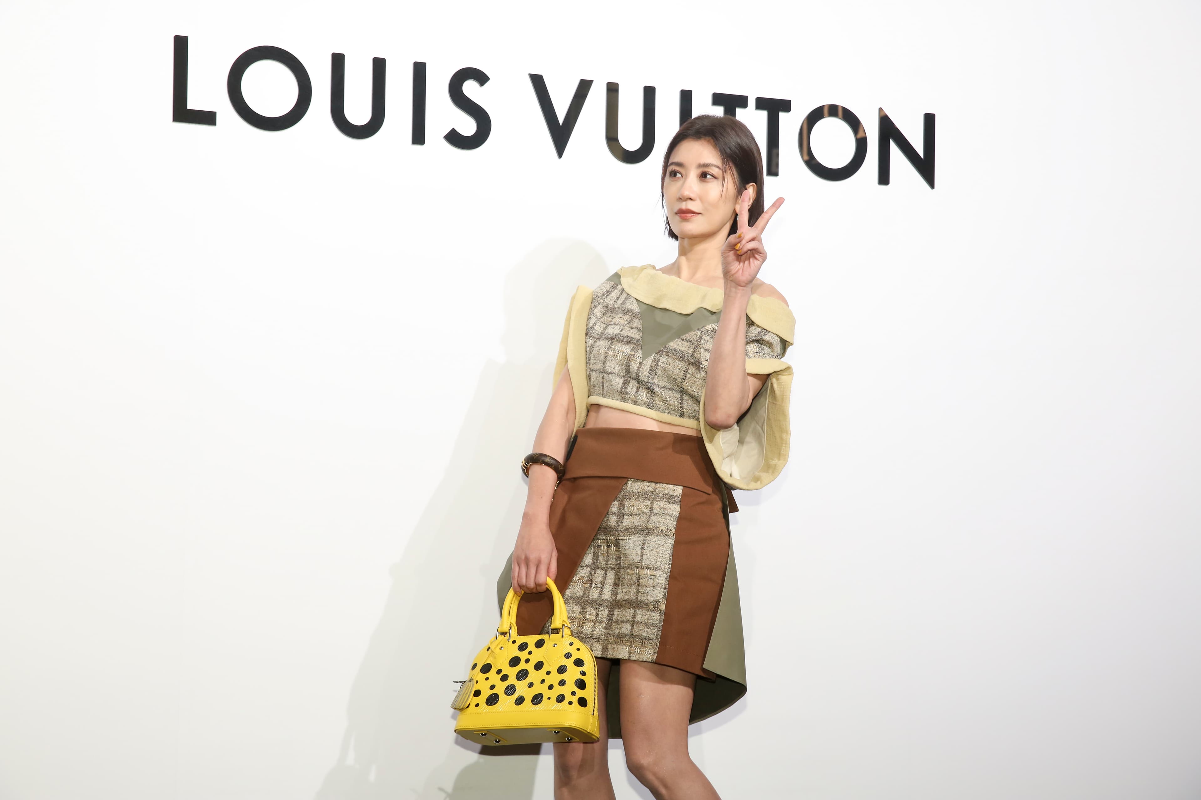 賈靜雯身上的LV小羊皮裝飾平底領闊身上衣NT$141,000、垂褶皮革迷你半截裙NT$154,000、LV X 草間彌生Alma BB黃色手提包NT$87,500。