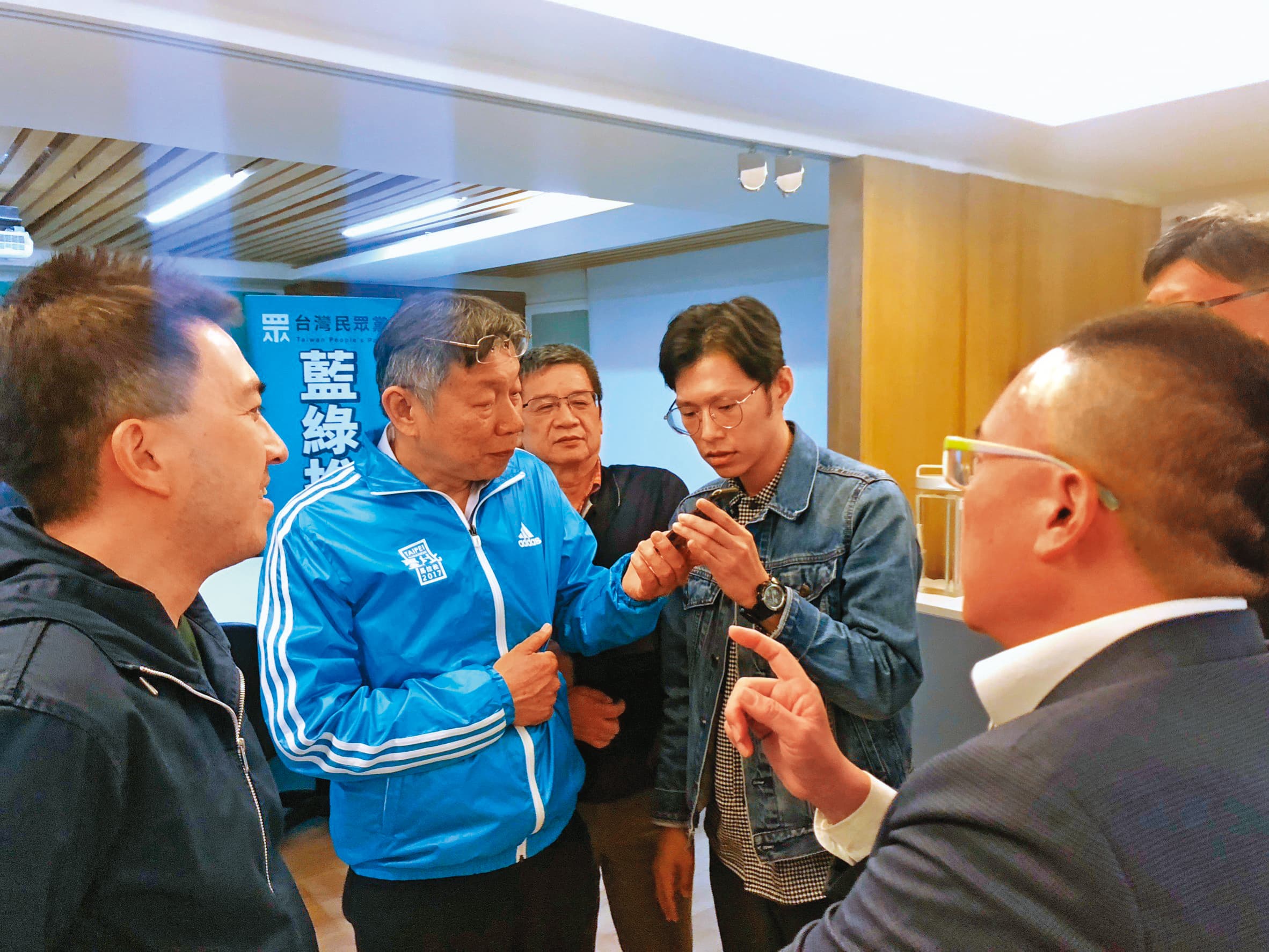 謝泊泓(拿手機者右)是柯文哲(拿手機者左)核心幕僚,2020年大選開票之夜本刊專訪柯時,他更是少數陪同受訪的幕僚。(黃驛淵攝)
