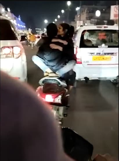 機車騎士騎車時,女友正面緊抱他還熱情擁吻。(翻攝Youtube頻道「Indian Journo」)
