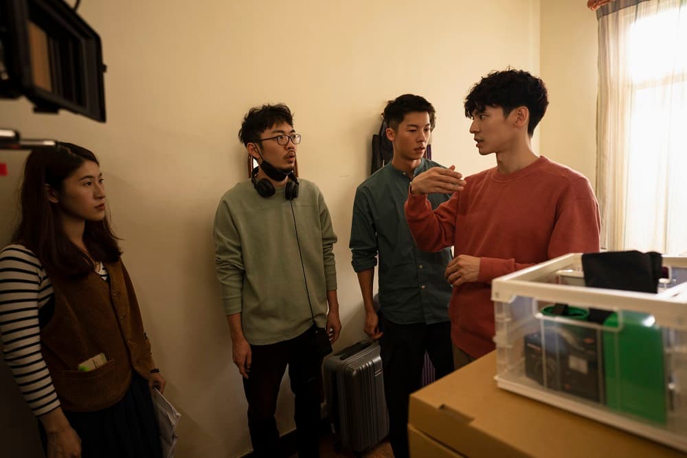 林柏宏(右起)與許光漢在拍片現場與導演程偉豪、表演指導百白討論。(金盞花大影業提供)