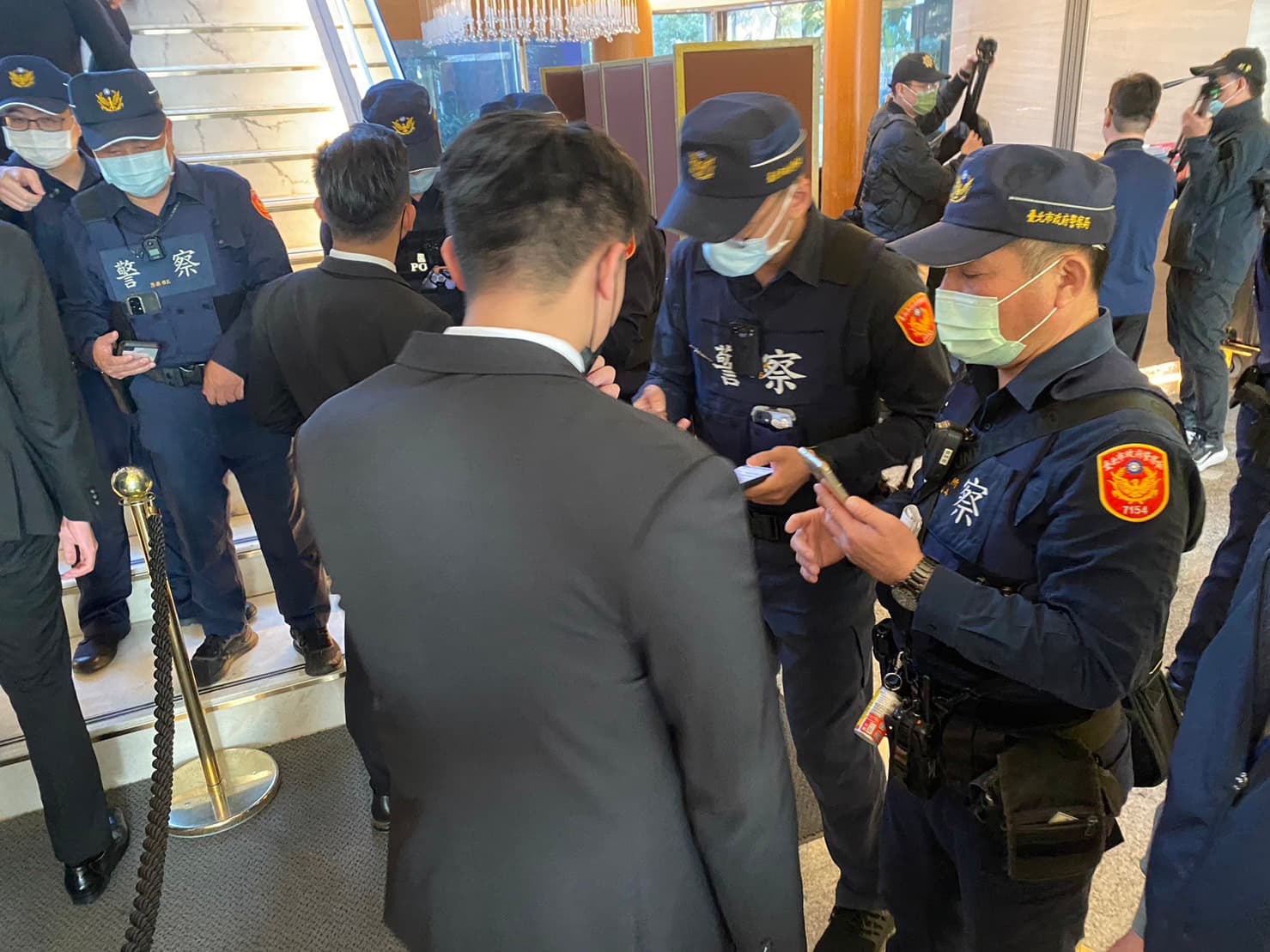 警方在飯店各出入口派駐警力，盤查與宴人士身分。（翻攝畫面）