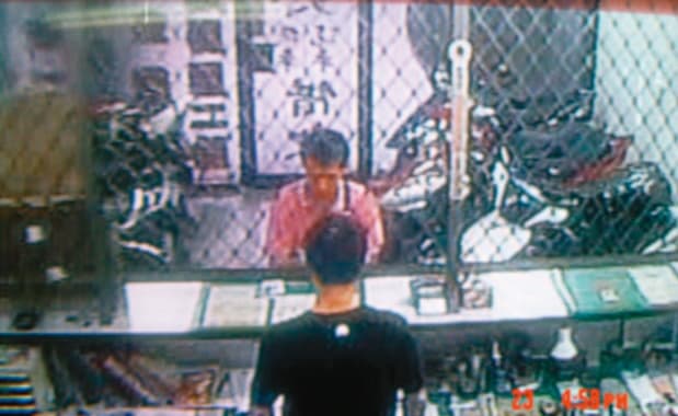 林男(上)拿著死者的錢,到當鋪贖回自己的機車,被監視器拍下。(翻攝畫面)