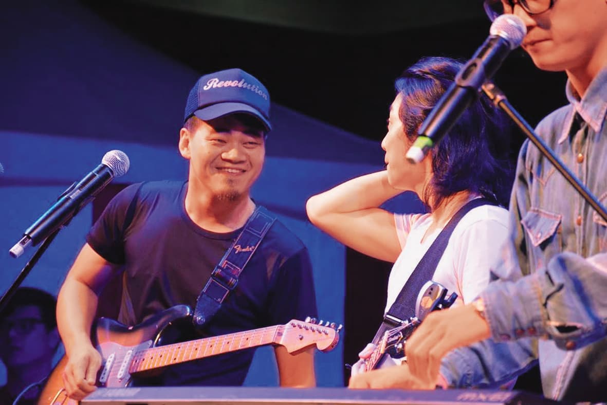 過往吉他手阿任在舞台上演出,與其他成員互動自然。(翻攝自茄子蛋臉書)