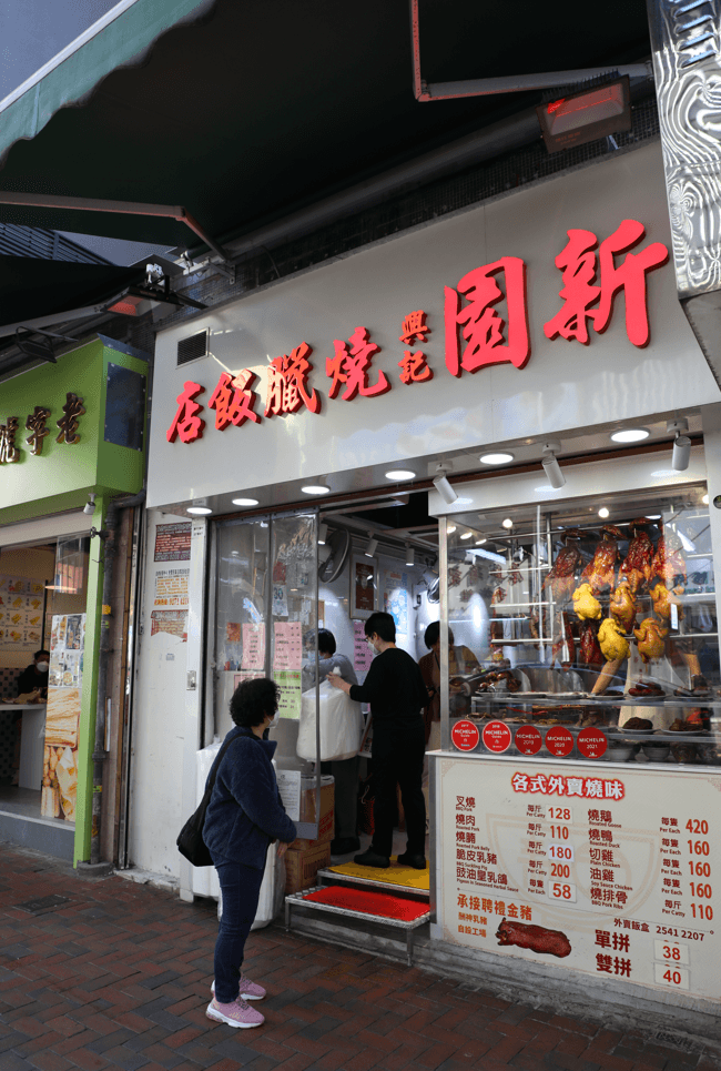 「新園興記燒臘飯店」搬家後有嶄新店面,臘味櫥窗明亮乾淨。