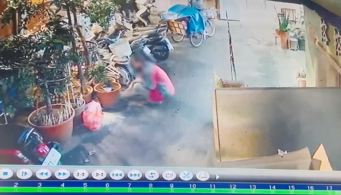 嫌犯蹲地偷偷把兇刀丟在一處盆裁空隙。(翻攝畫面)