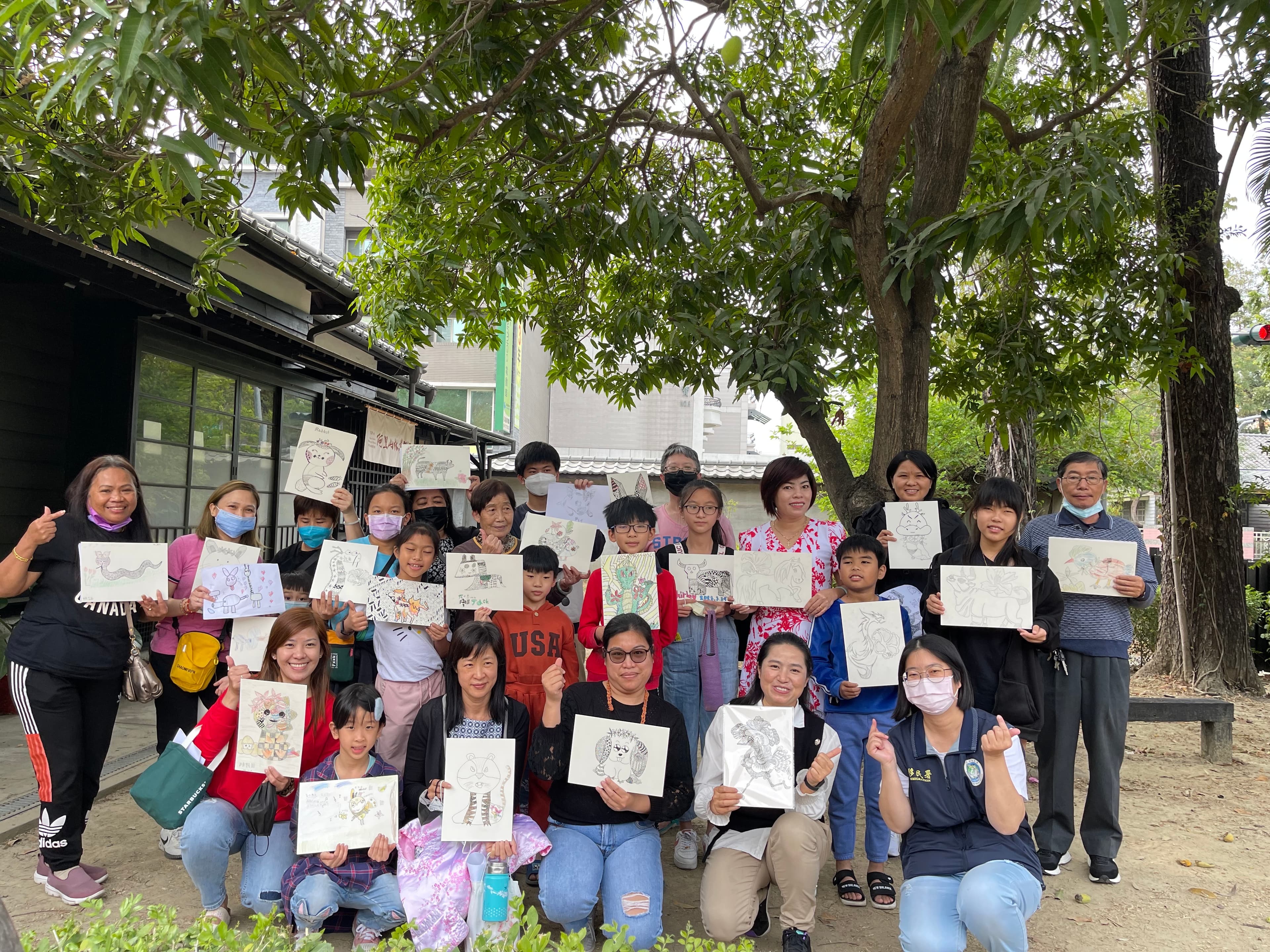 參與的新住民家庭開心地拿著作品與講師申婷頡(前排右二)合影。(移民署提供)