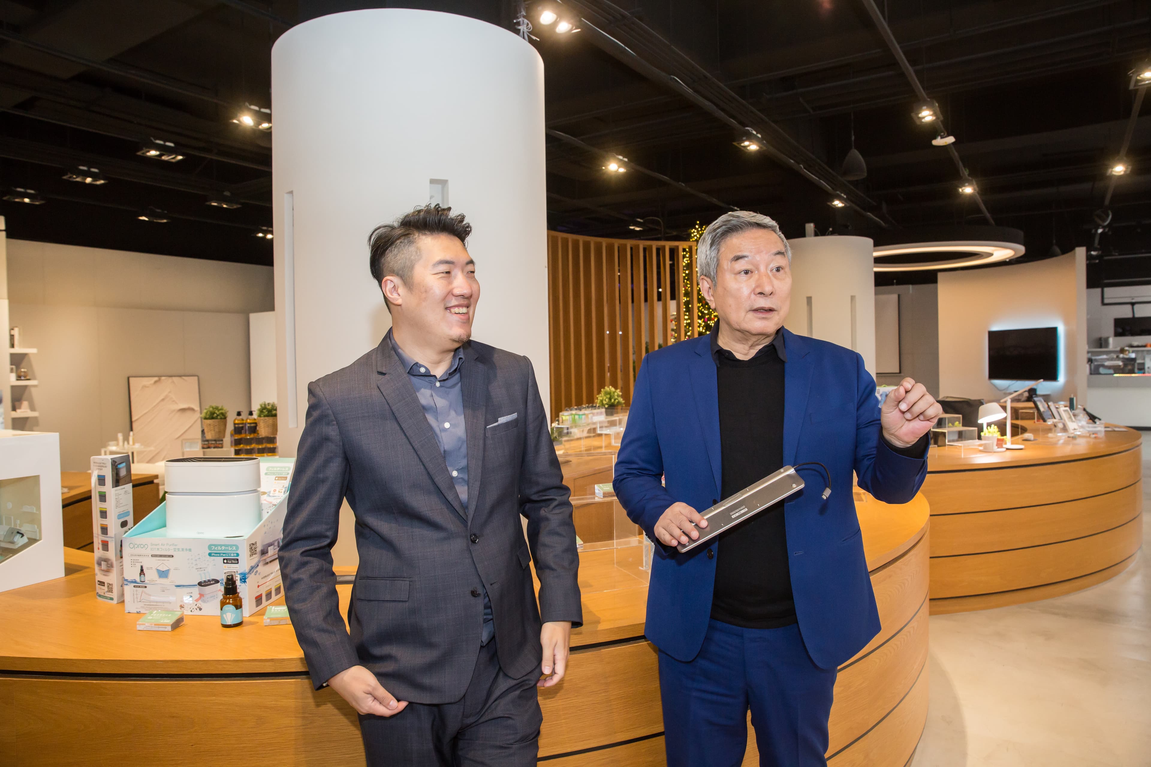 楊超群（右）與兒子楊奕康（左）著重發展自有品牌O’pro9，楊超群手上的多功能轉接器也是連接器的應用，可連接筆電、手機、平板和電視螢幕。