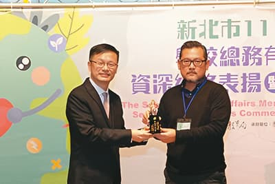 積穗國小總務主任陳振豪(右)曾獲新北市教育局頒獎表揚。(新北市教育局提供)