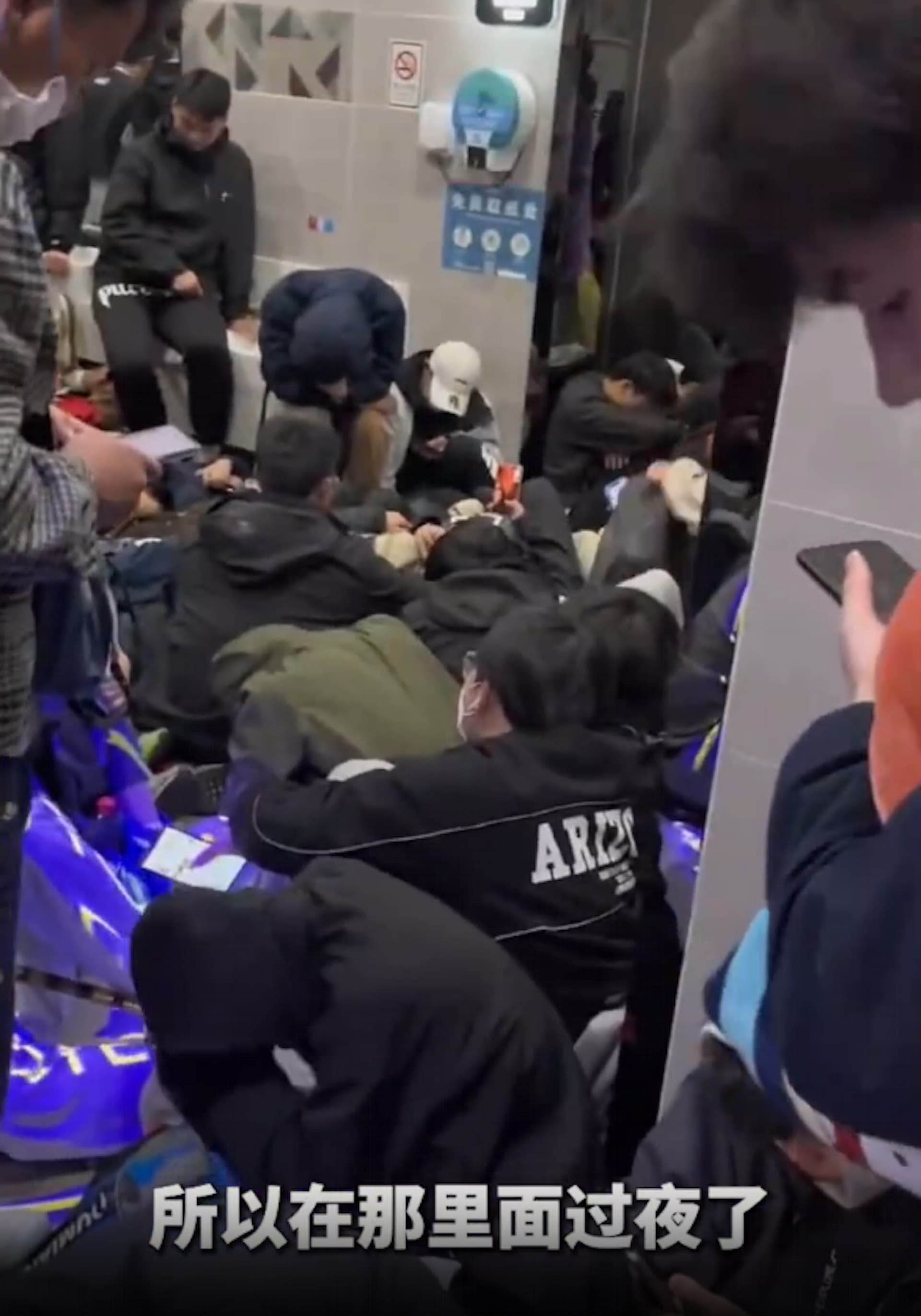 大批民眾直接睡在公廁的走道。(翻攝自微博)