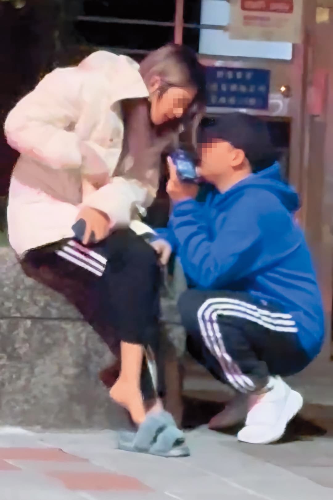 3月31日樂兒接到電話坐在路邊,黑帽男蹲下和她同跟友人講電話。(讀者提供)