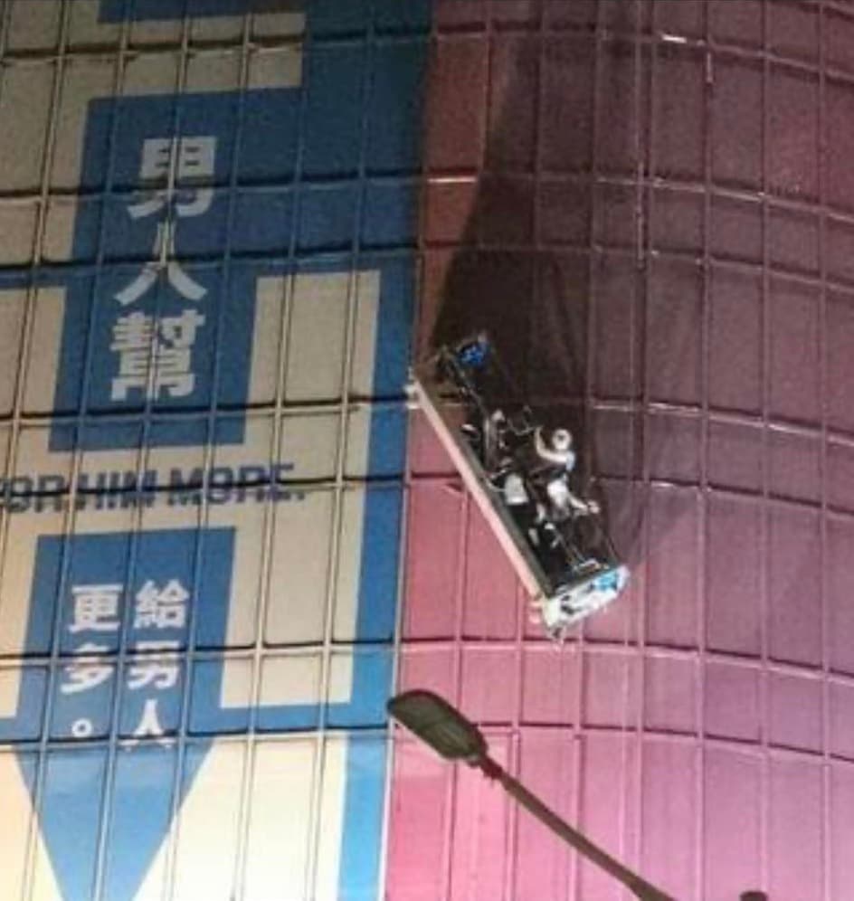 北市環亞大樓1日深夜發生工安意外，3名工人在外牆施工時發生吊籠傾斜，受困在空中險象環生。（翻攝臉書「●【爆料公社】●」）