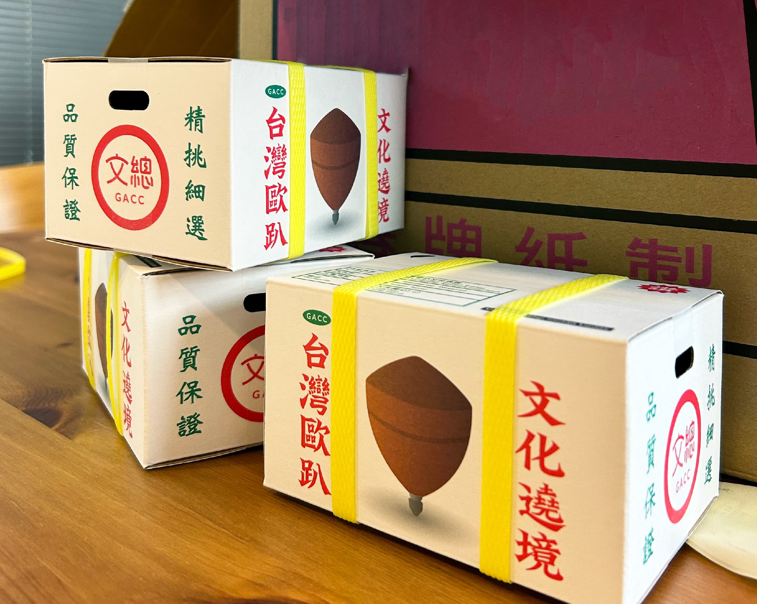 以台灣常見的紅白配色水果箱,作為陀螺的外包裝,配上黃色封箱繩與產品標示等設計,充滿濃濃台味。(文化總會提供)