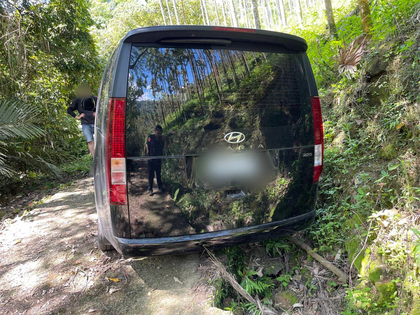 新加坡劉姓遊客帶妻小來台自駕觀光，在南投縣國姓鄉山區迷路且車輪陷進路邊泥土。（埔里分局提供）