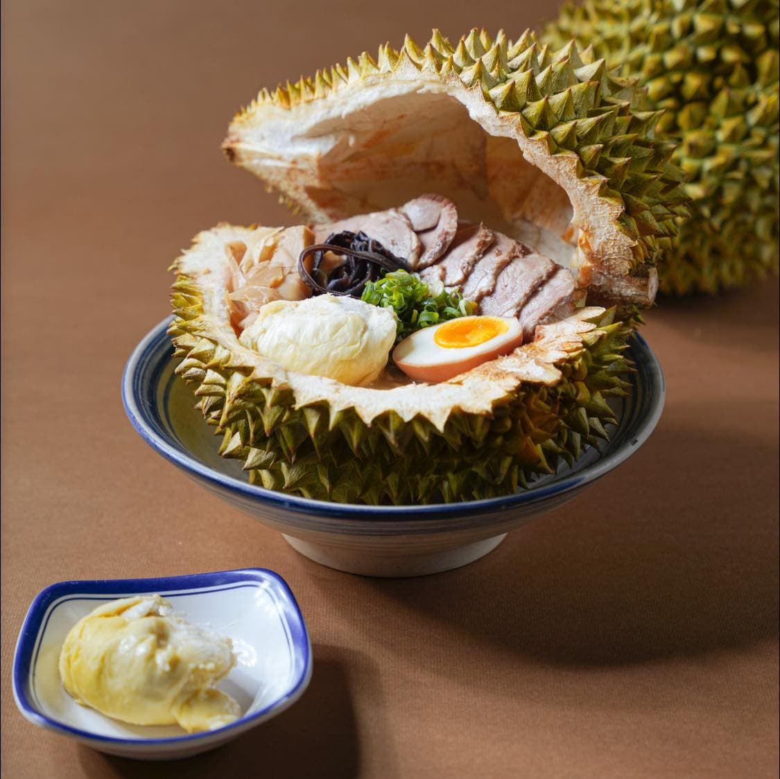 「榴槤拉麵」以椰奶豚骨作為拉麵湯底,再把新鮮的榴槤果肉打成泥融入湯底。(翻攝自山禾堂拉麵岡山店臉書)