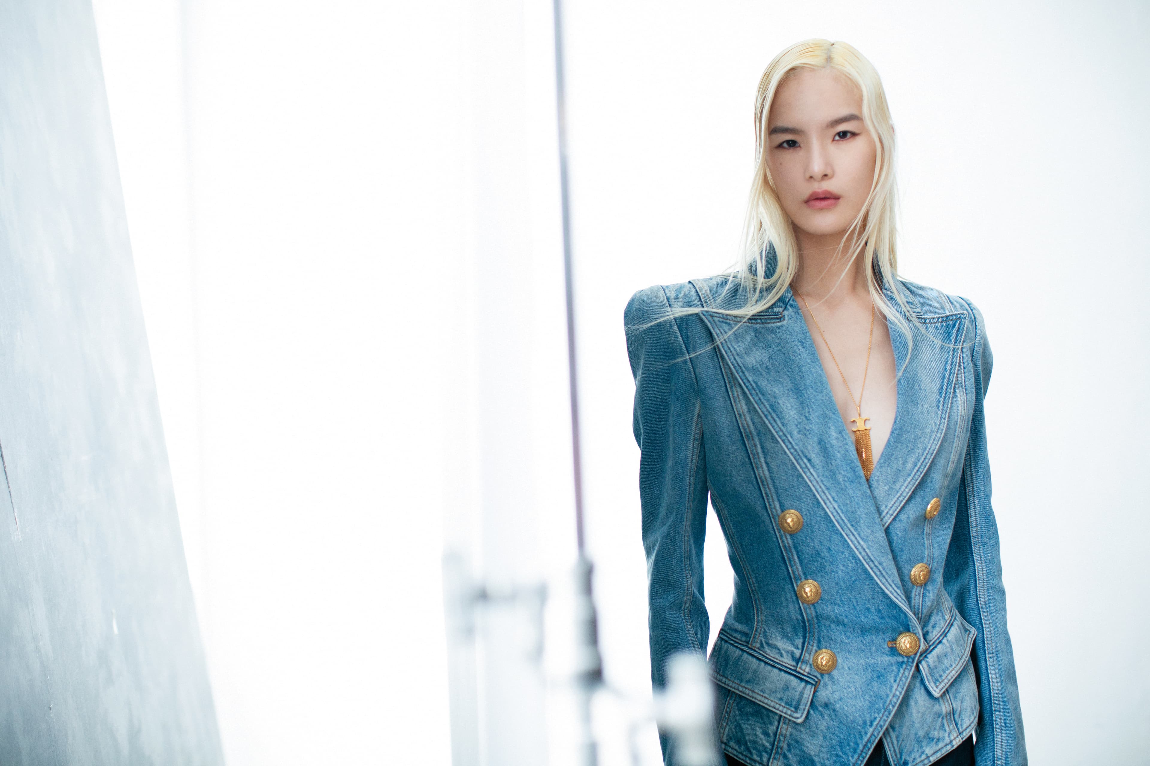復古鈕扣藍色牛仔夾克 NT$95,700 by BALMAIN；TRIOMPHE FOLK流蘇長項鍊 NT$30,500 by CELINE BY HEDI SLIMANE。