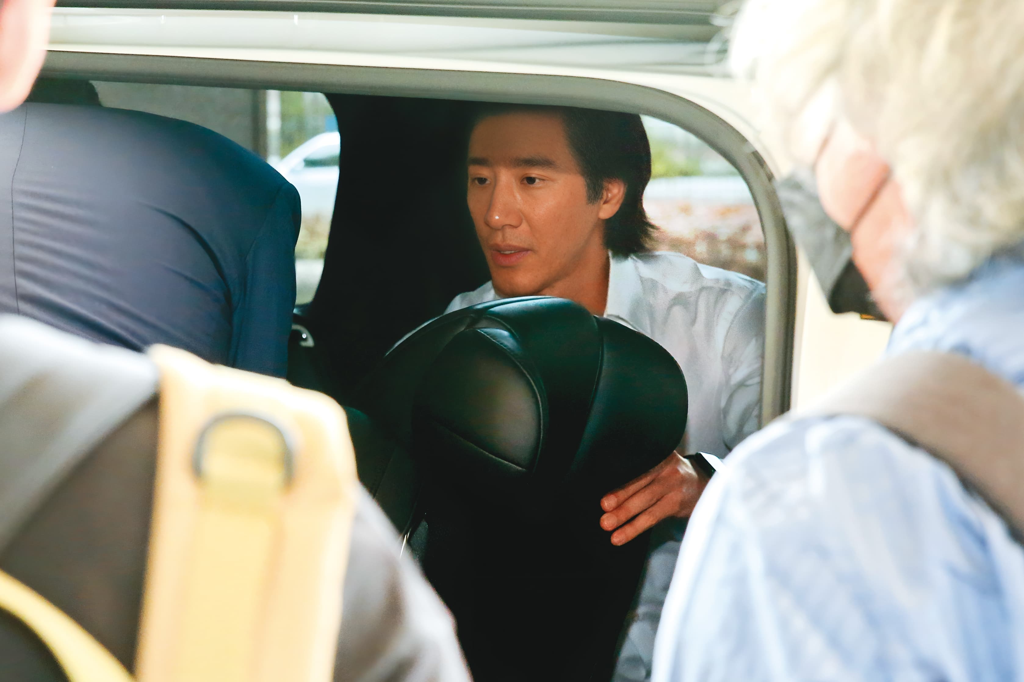 6月28日12:32,上了車後,王力宏貼心幫律師與工作人員喬起位置,展現親和力。