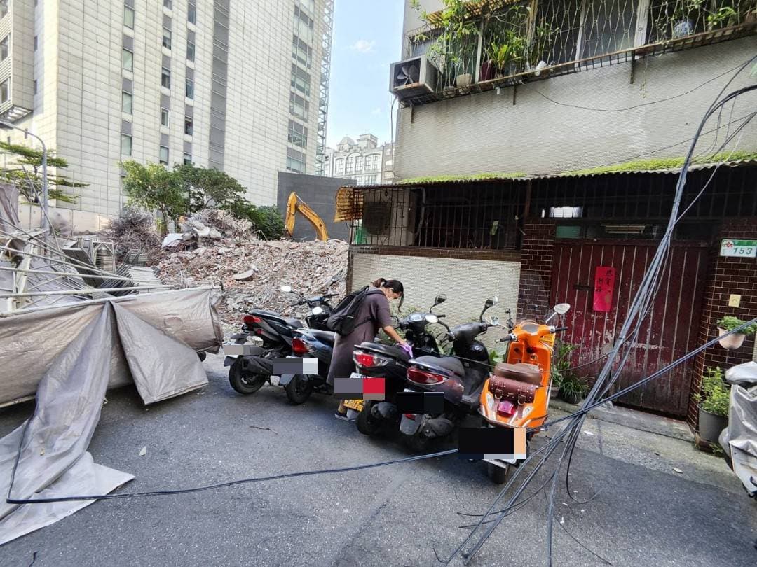 倒塌鷹架波及路邊機車,也把有線電視電纜扯下。(翻攝畫面)