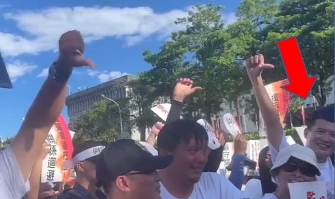 國民黨新北市議員陳偉杰直指民眾黨中央委員張凱鈞,在侯友宜致詞時混在人群中帶頭比倒讚。(翻攝自陳偉杰 Chen Wei-chieh臉書)