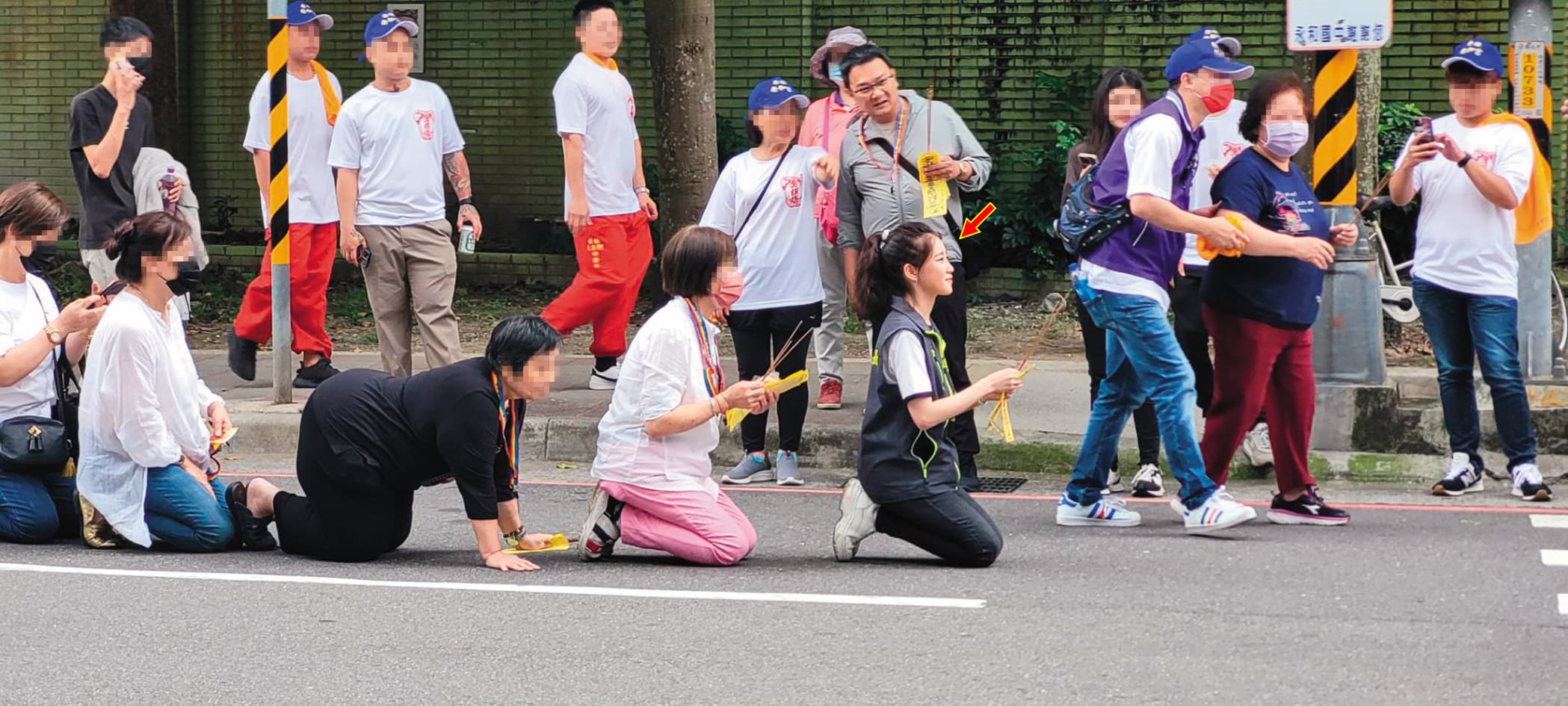 陳紫渝(箭頭處)熱心里上事務,帶著家人及里民在路邊迎媽祖神轎。