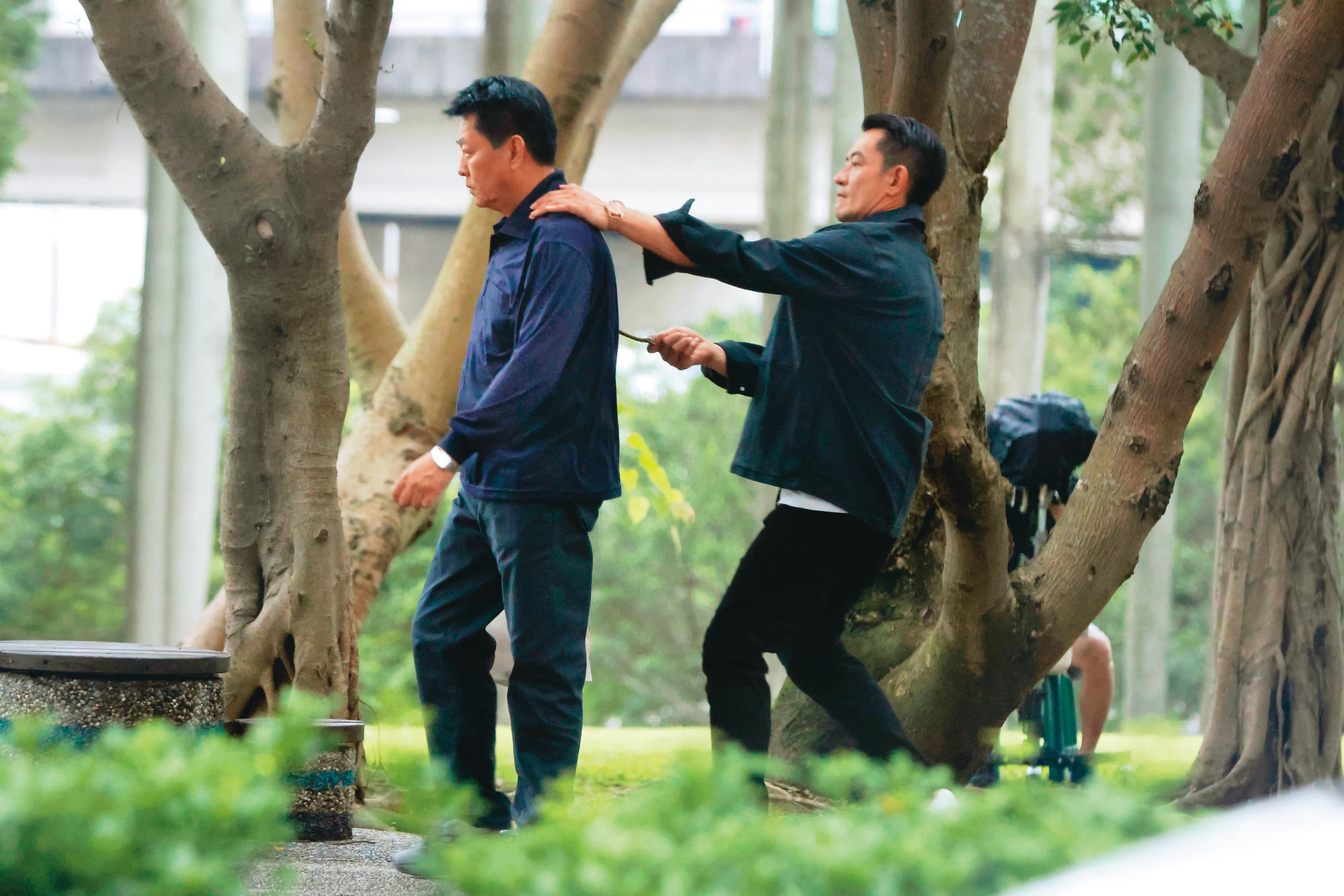 15:58,柯叔元(右)拿了樹枝從背後頂著庹宗華(左),像是在威脅他,兩人正拍攝衛視新戲。